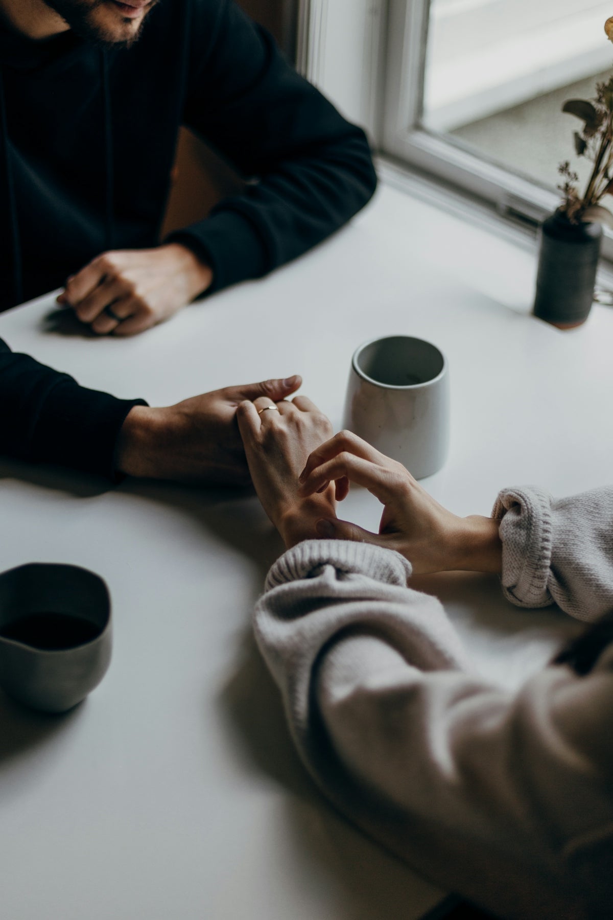 two people holding hands at table