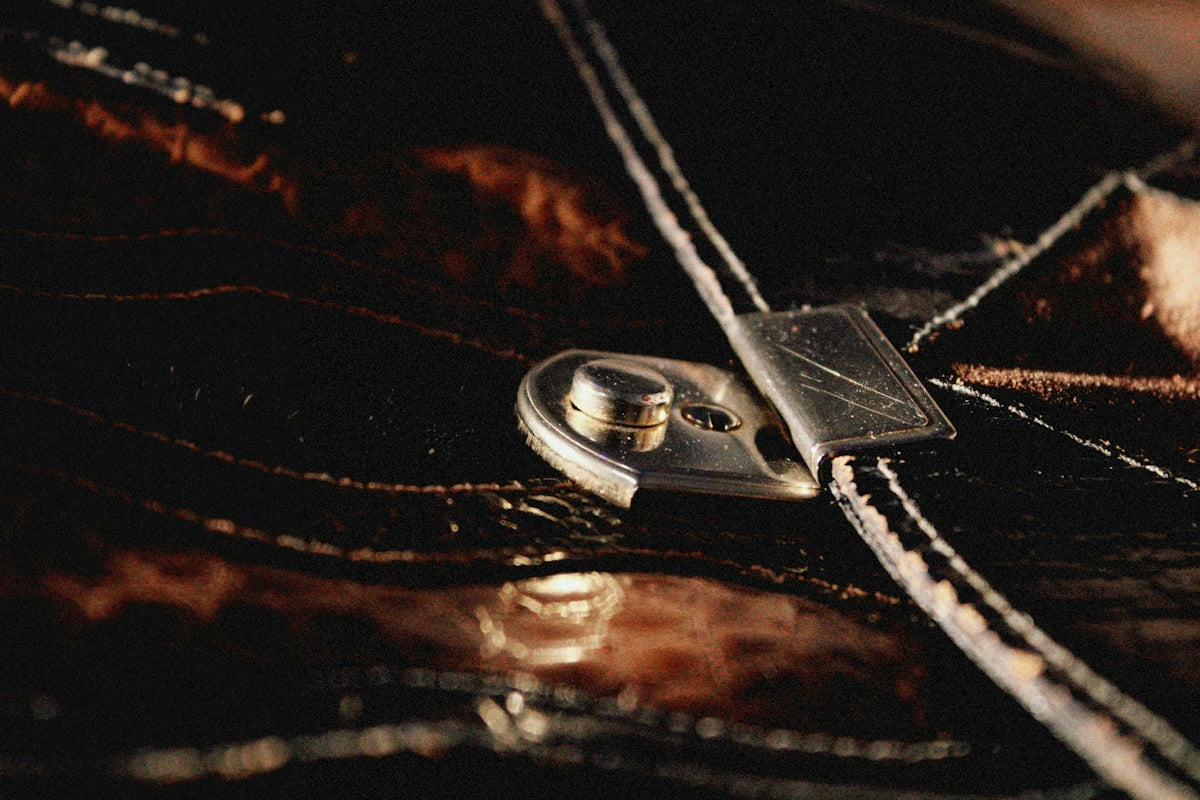 a close up of a button on a leather purse