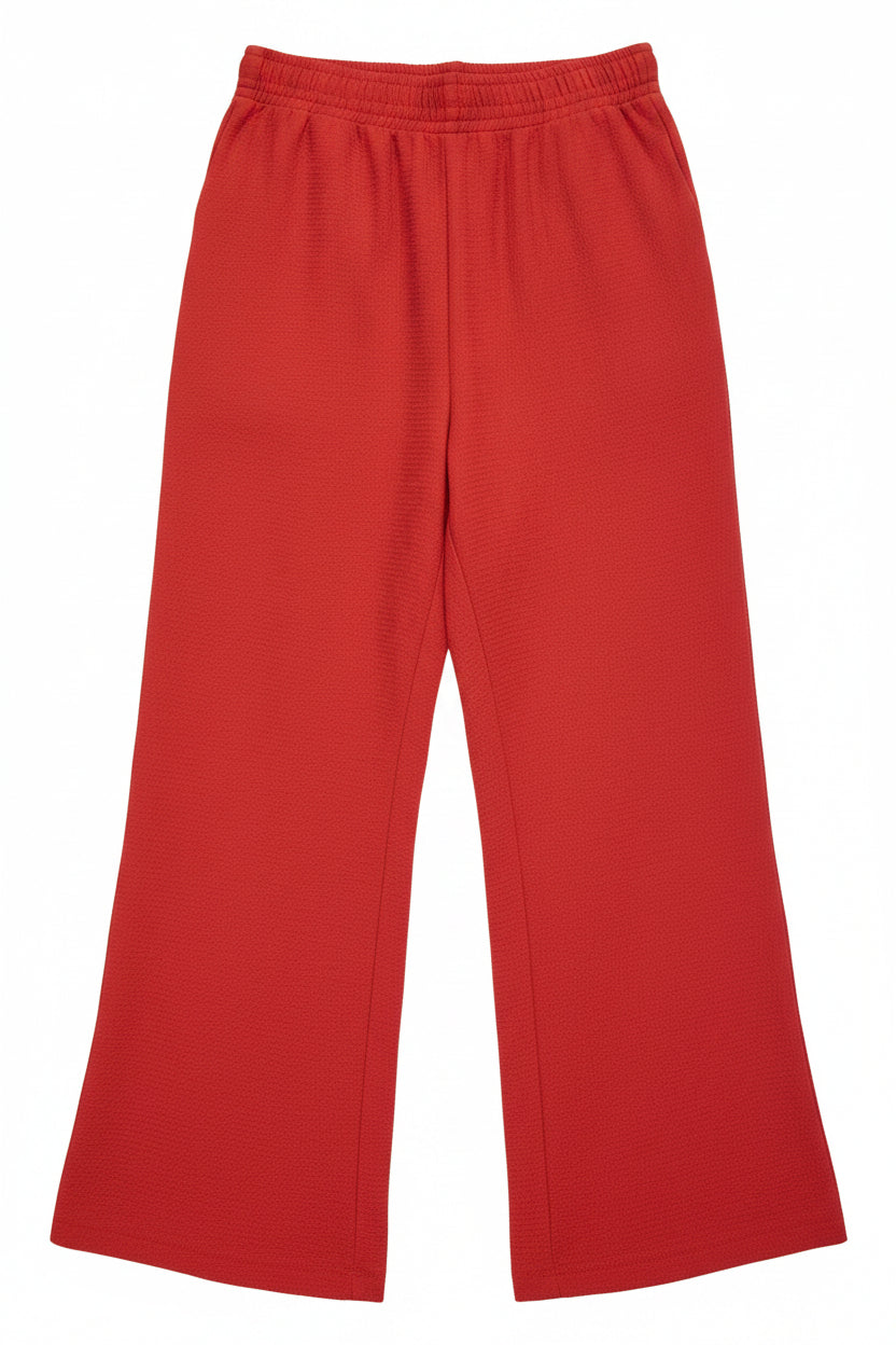 A pair of red wide-leg trousers with an elasticated waistband and a textured woven finish.