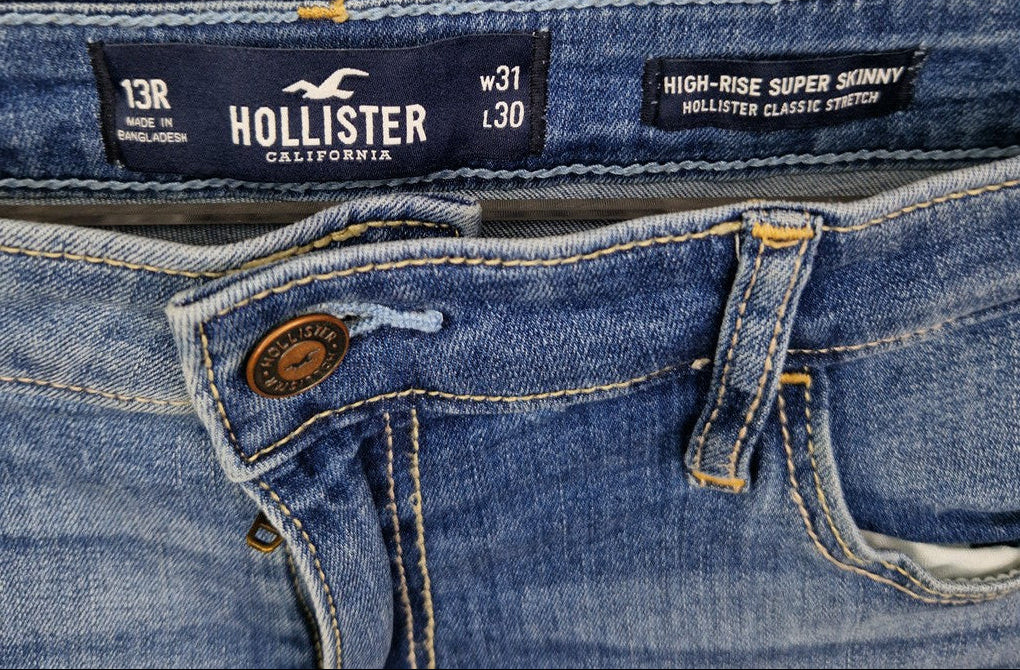 A close-up of blue Hollister high-rise super skinny jeans with a button fly and size W31 L30.