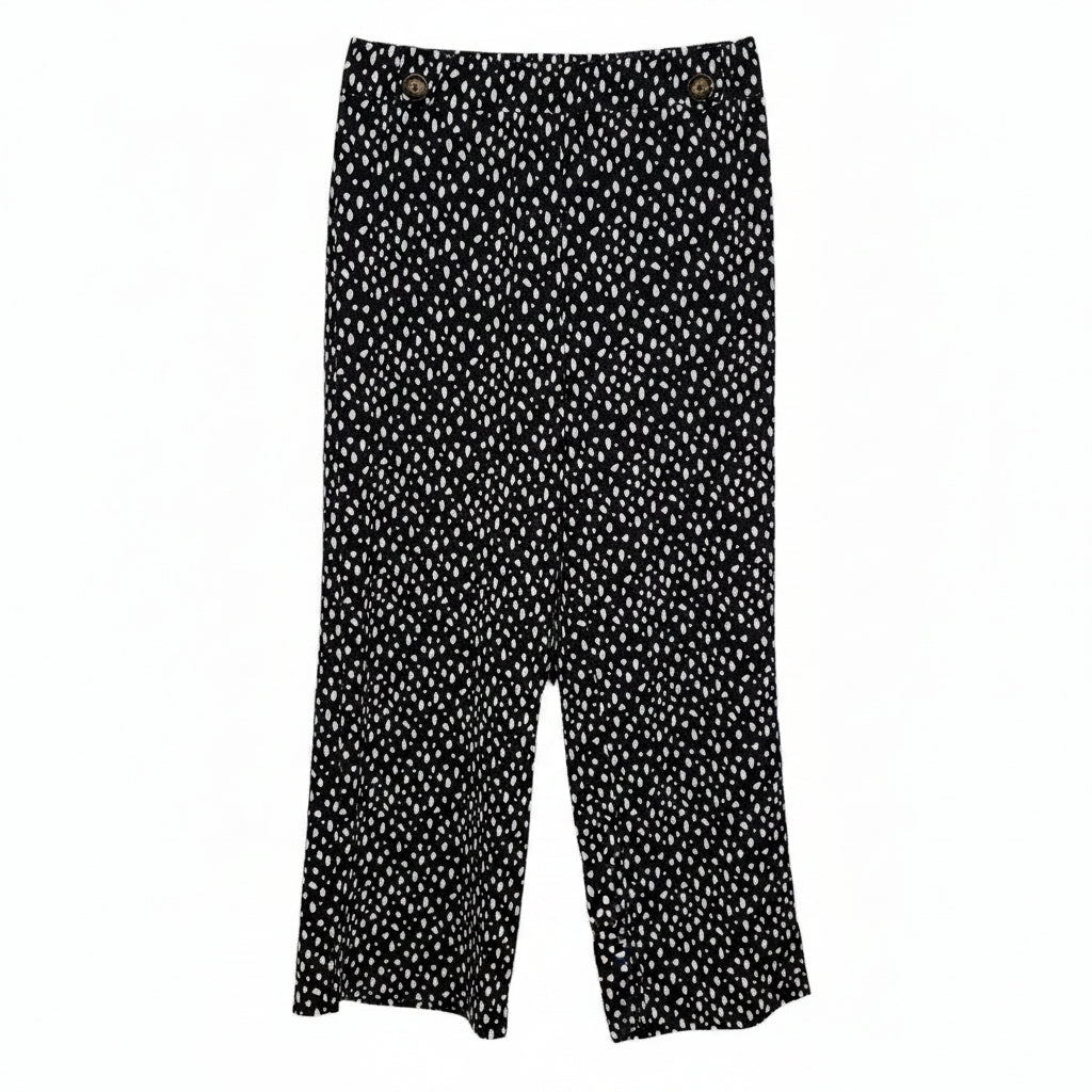 Black tapered trousers in a white speckled print with button details at the hem.