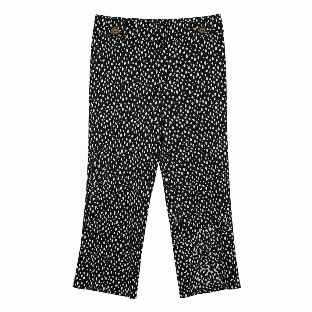 Black tapered trousers in a white speckled print with button details at the hem.