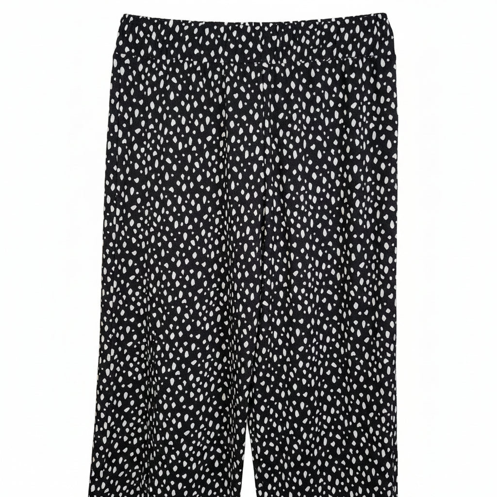 Black tapered trousers featuring a white speckled pattern and an elasticated waistband.