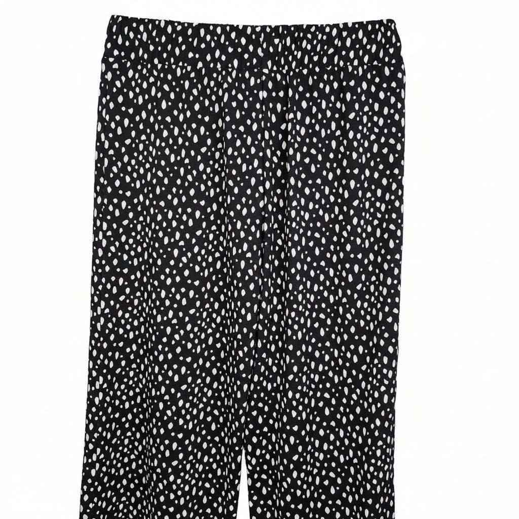 Black tapered trousers featuring a white speckled pattern and an elasticated waistband.
