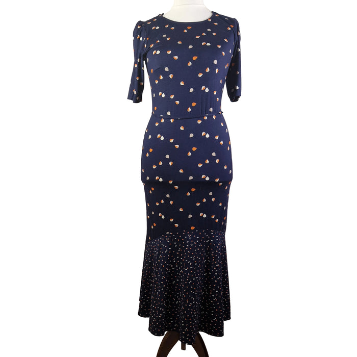 A navy blue fit and flare dress featuring a teardrop print and a ruffled hem on a mannequin.