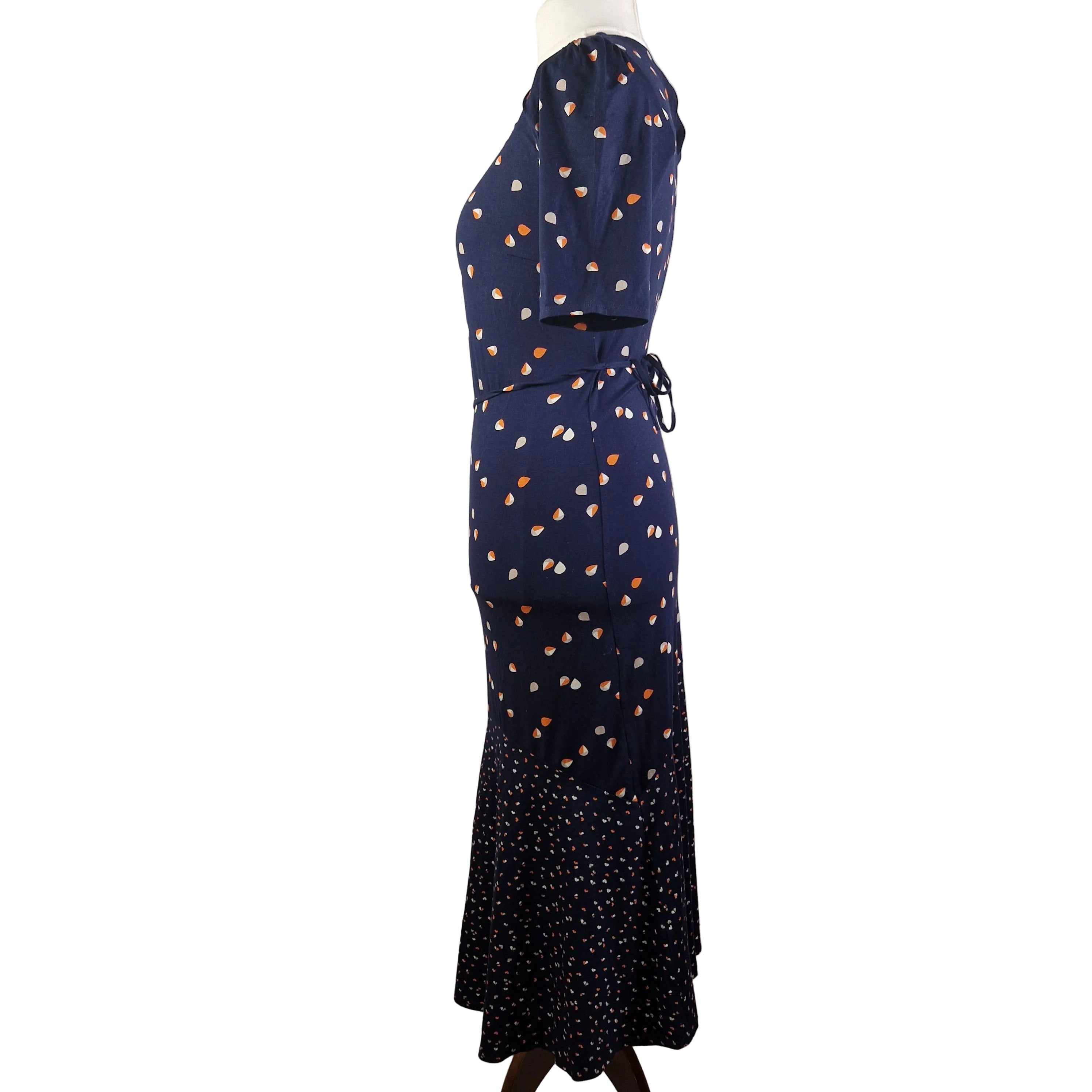 A navy blue fit and flare dress with a teardrop print and a contrasting patterned hem.