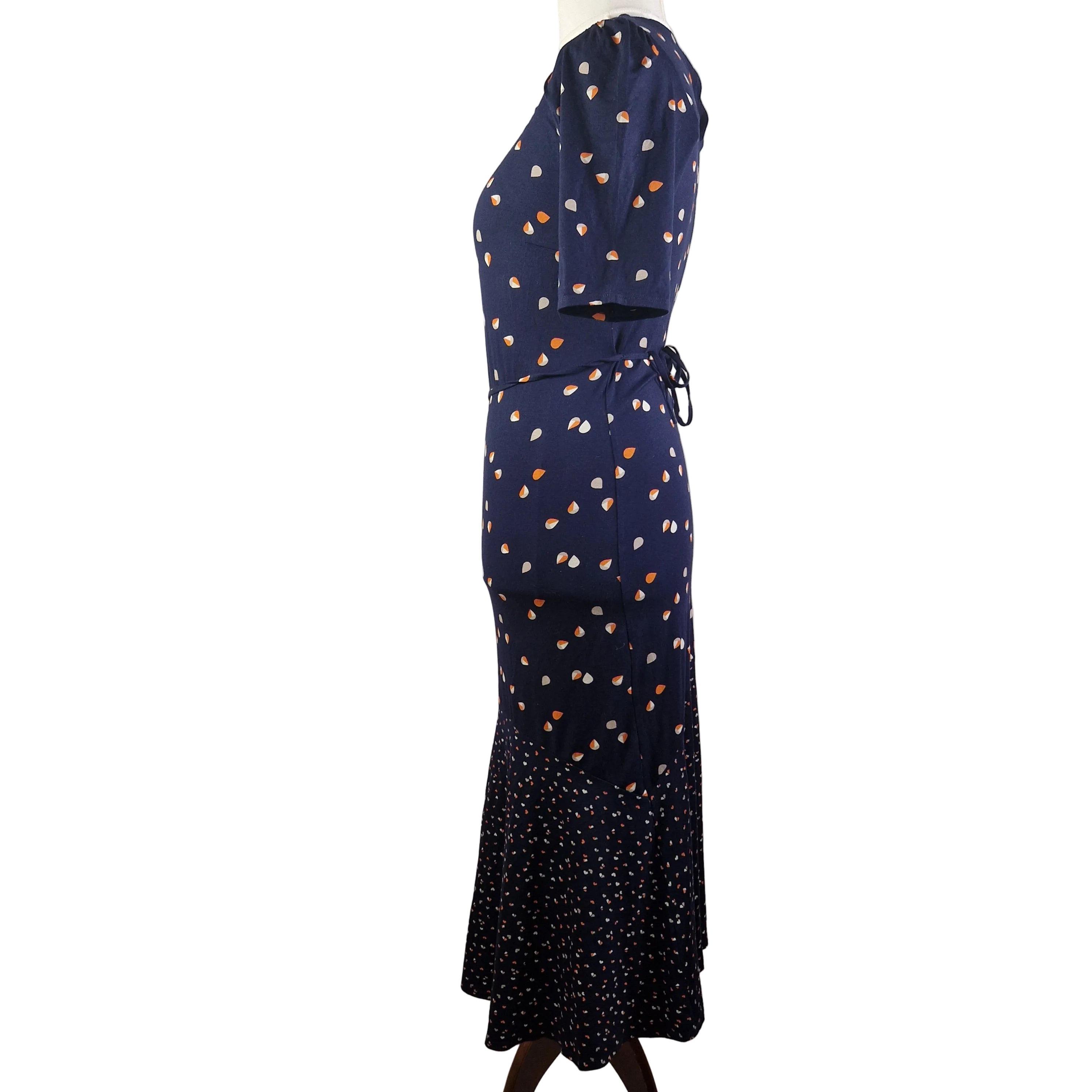 A navy blue fit and flare dress with a teardrop print and a contrasting patterned hem.