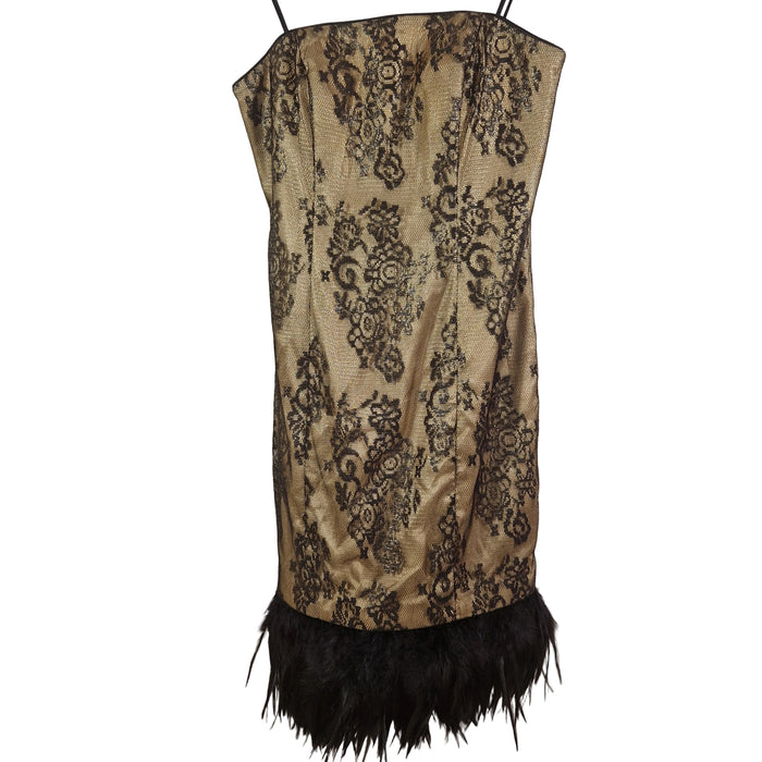 Beige dress with black lace and feather details on a mannequin against a plain background