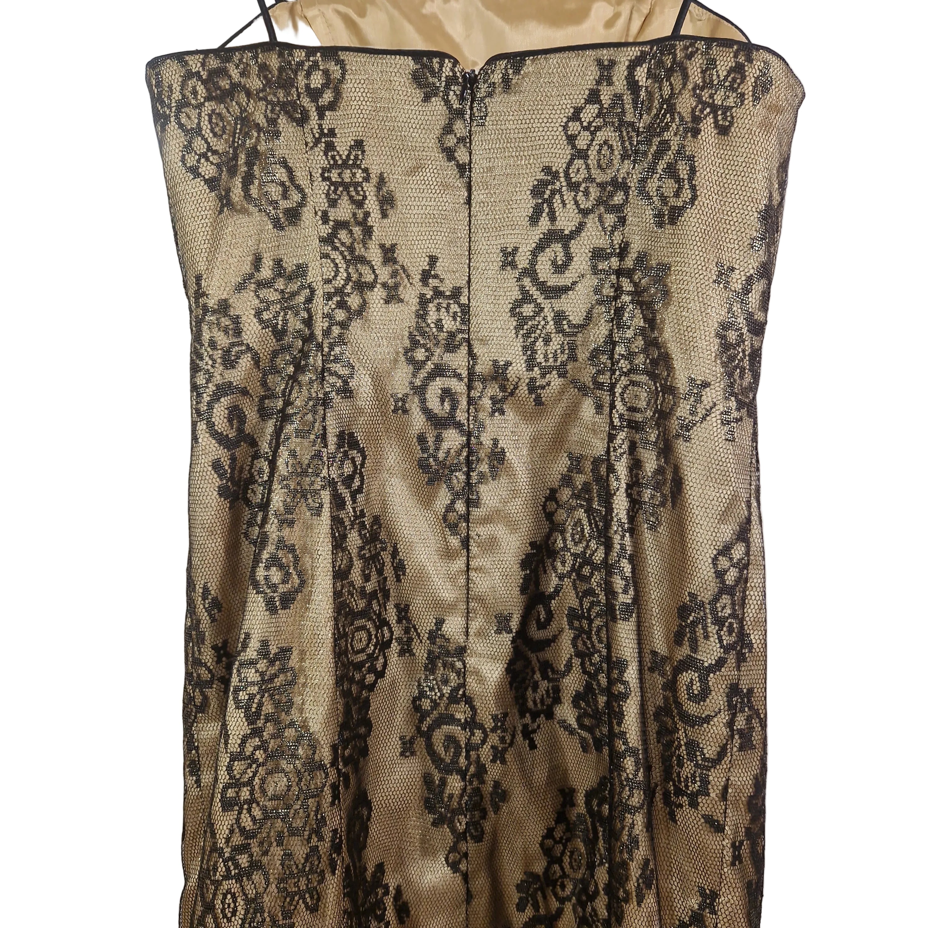 Close-up of a beige lace garment with black floral patterns on a white background