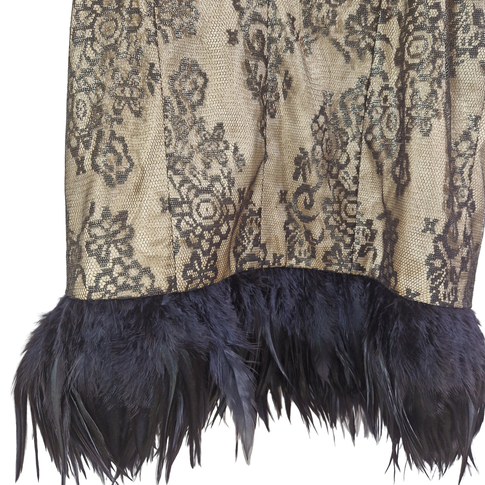 Textile with intricate pattern and dark blue feathers on a plain background