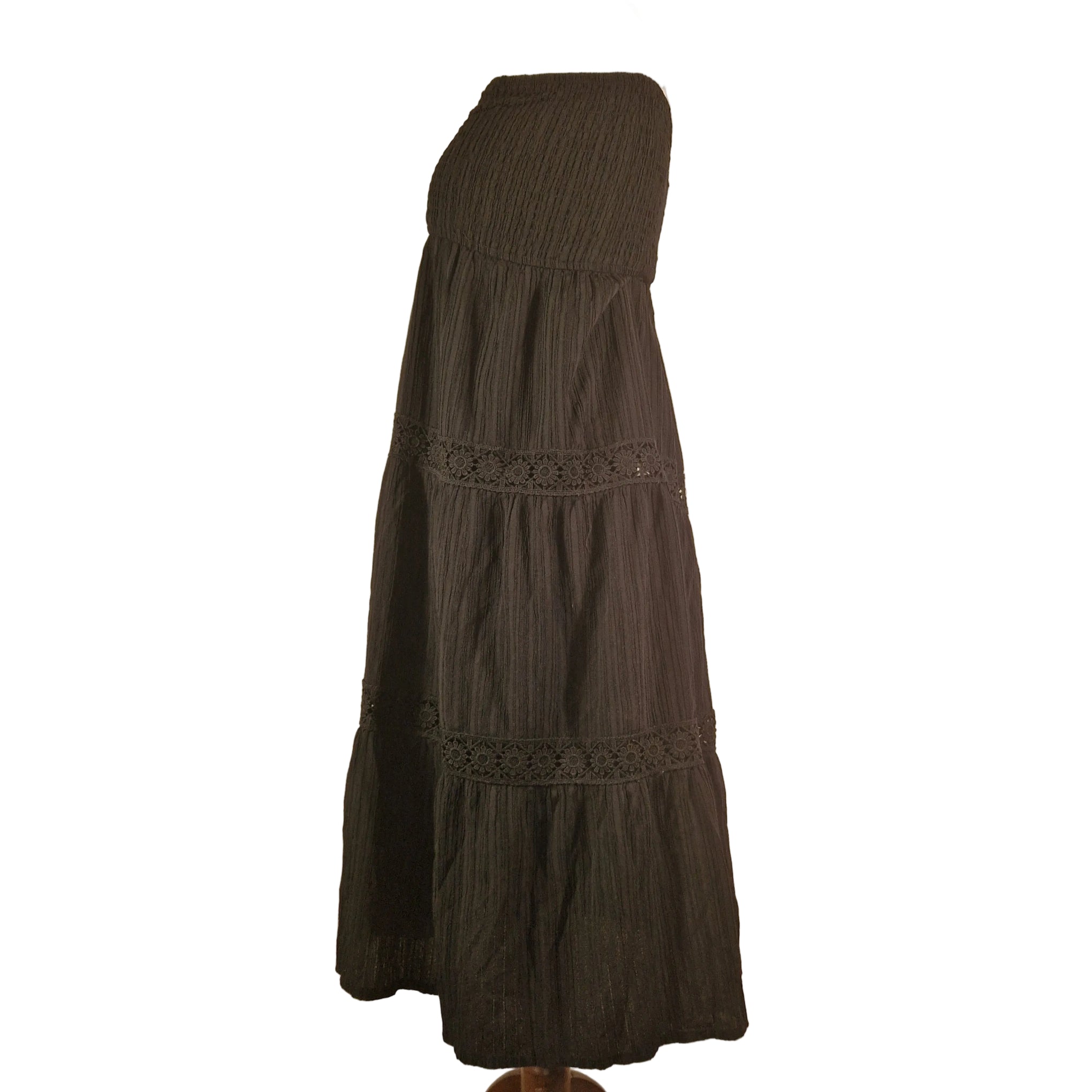Dark brown sleeveless dress with smocked bodice, elastic waist, and lace-trimmed hem.