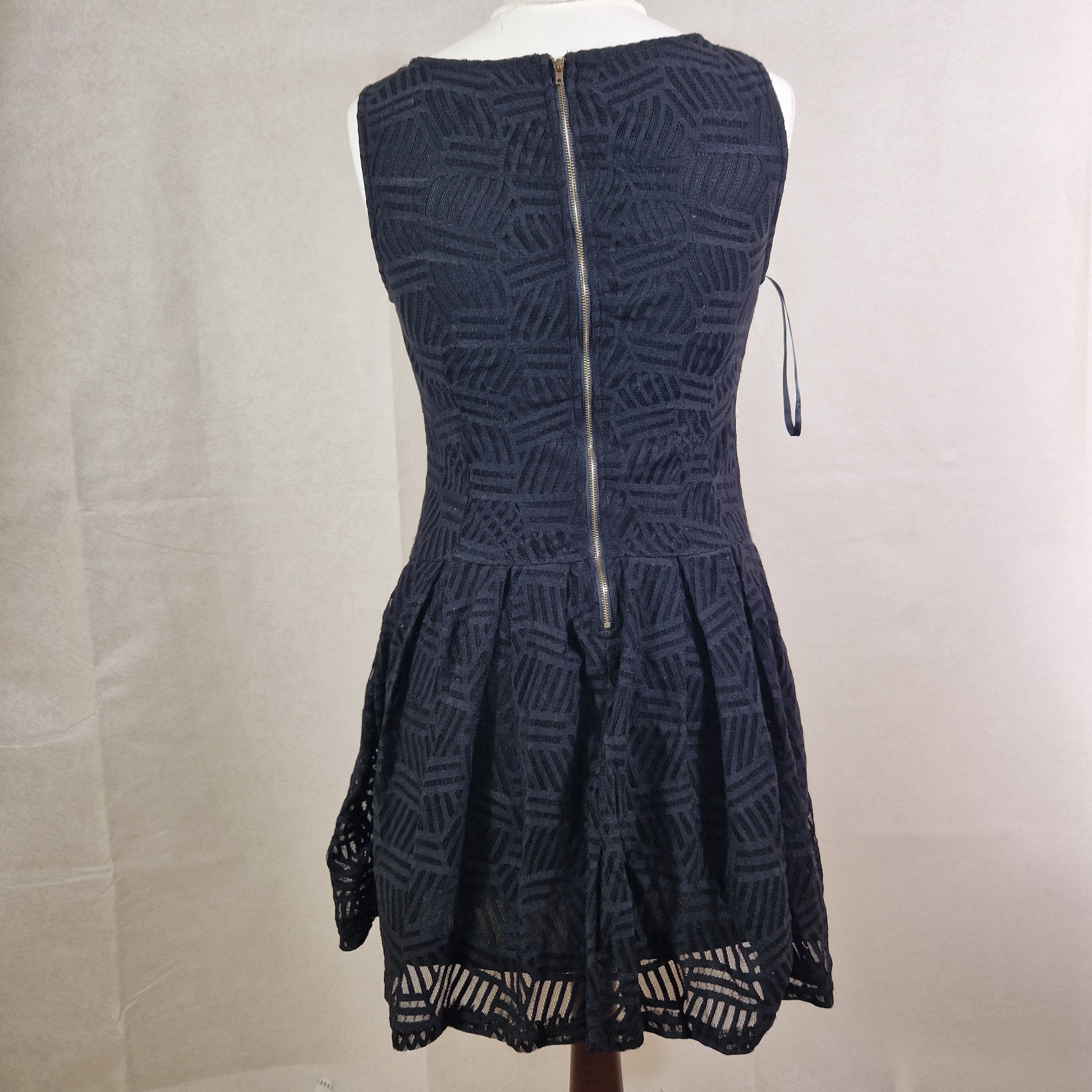 Black strapless dress with geometric pattern on a white surface