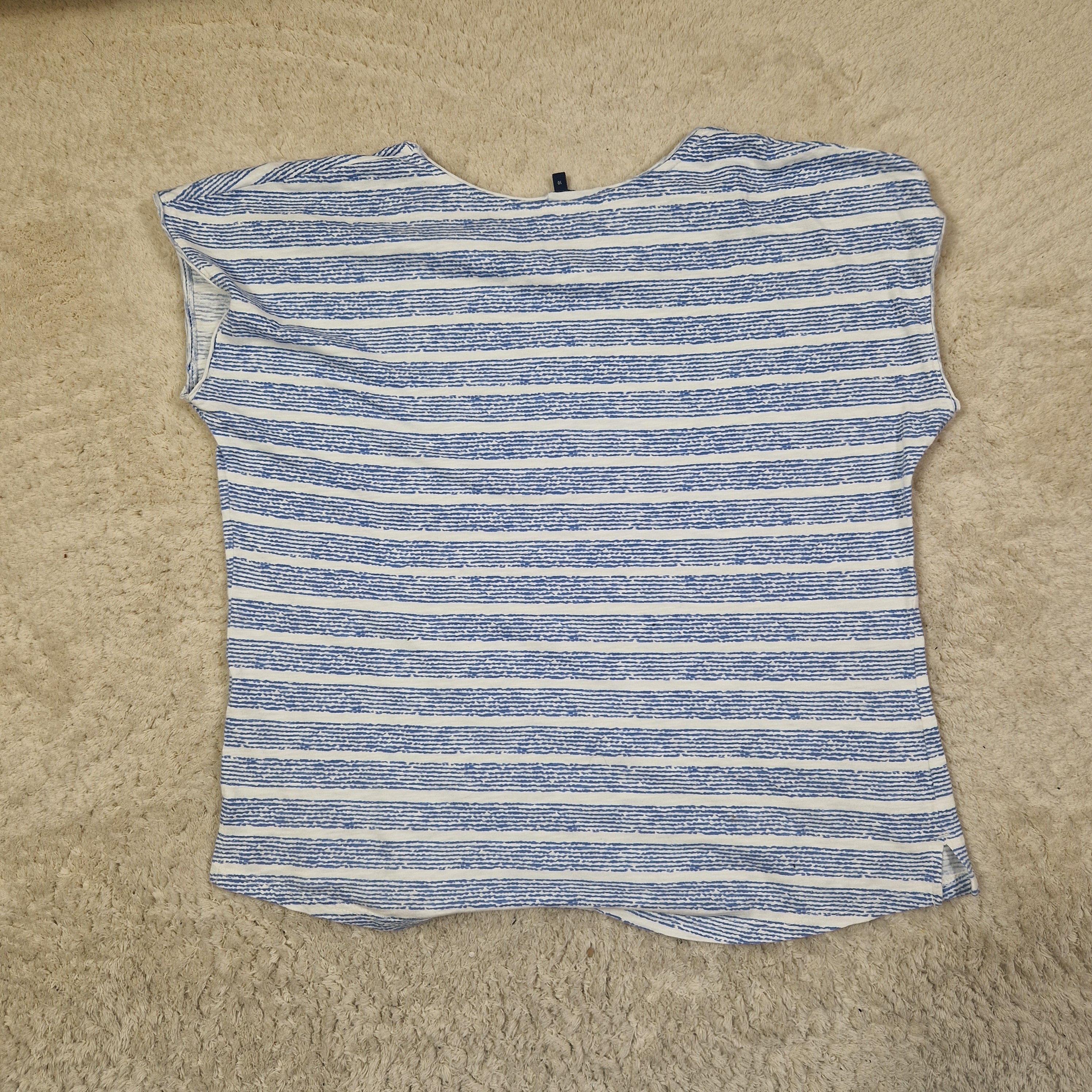 Blue and white striped sleeveless top on a beige carpet