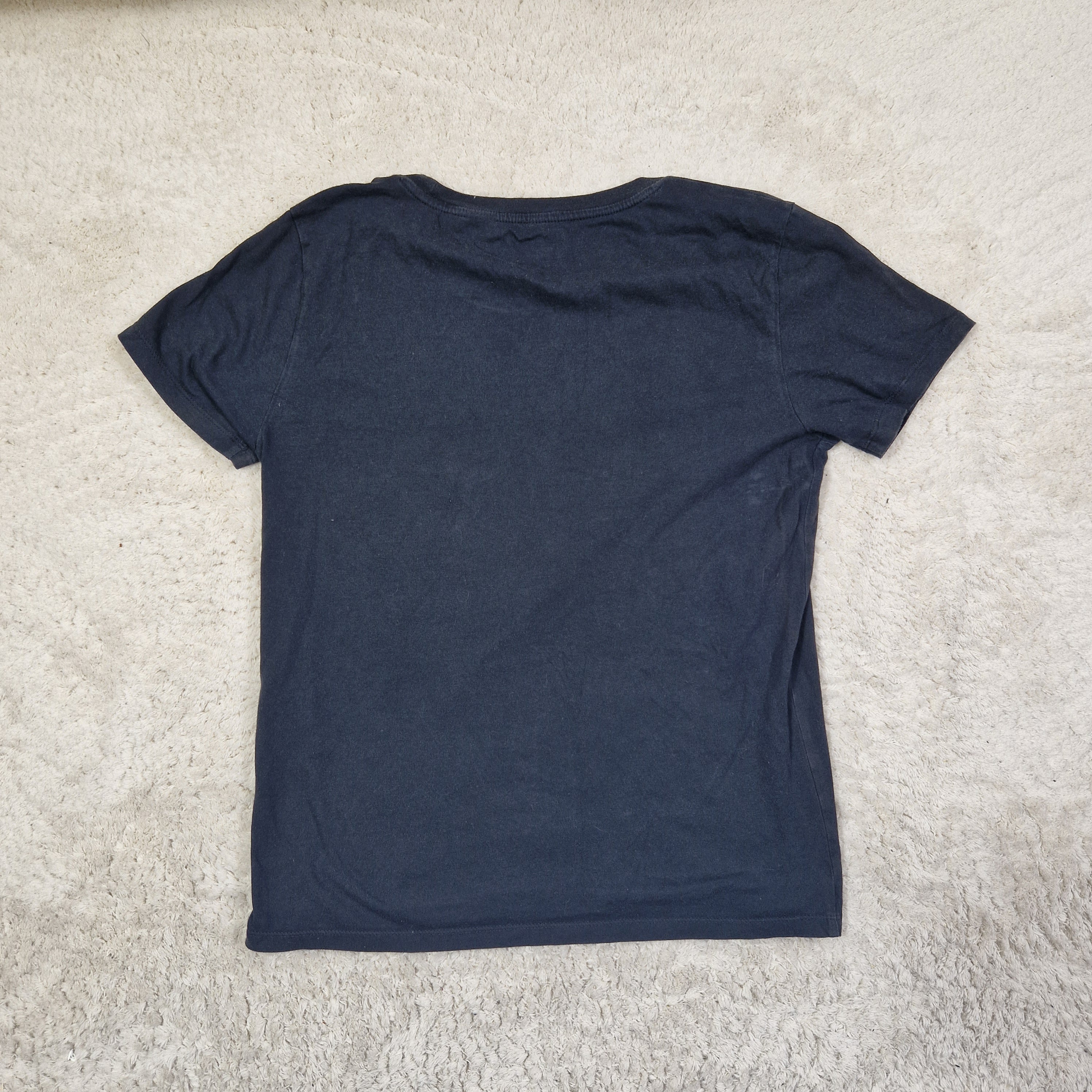Navy blue t-shirt on a beige carpet