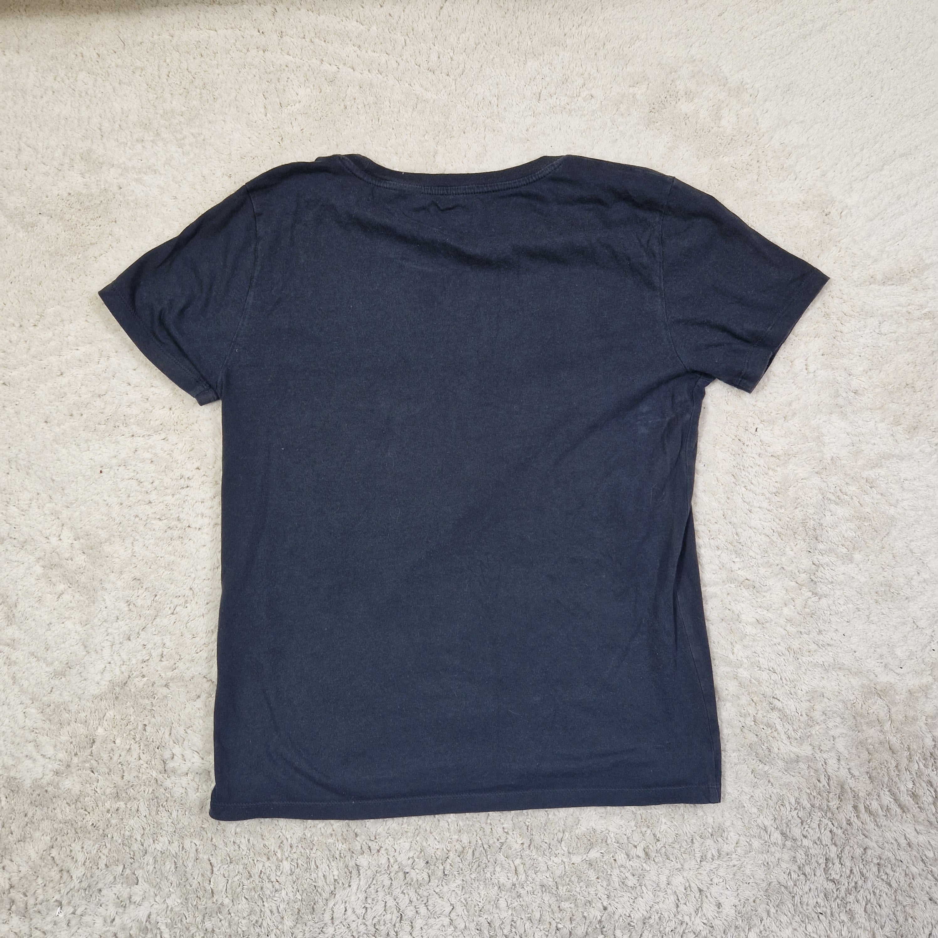 Navy blue t-shirt on a beige carpet