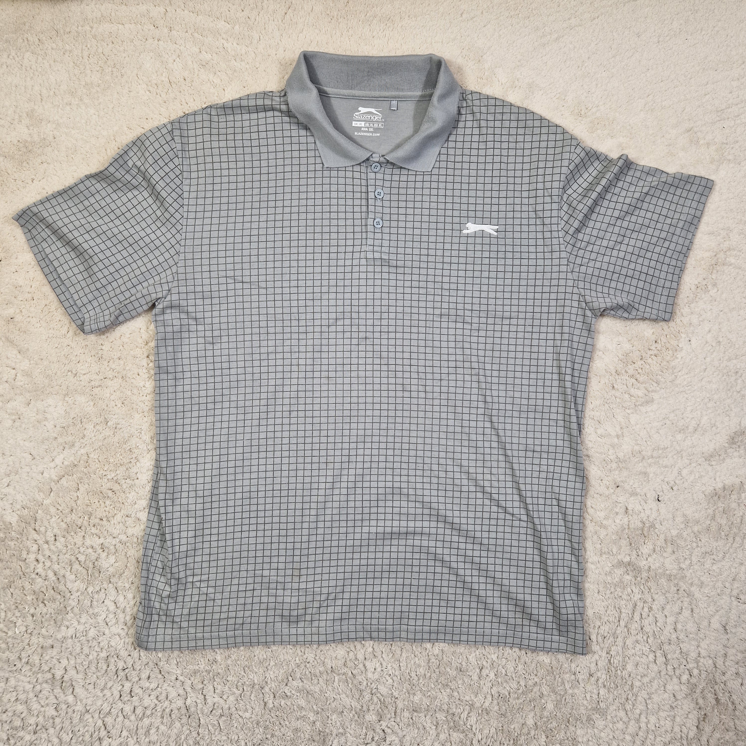 Gray checkered shirt on a beige carpet