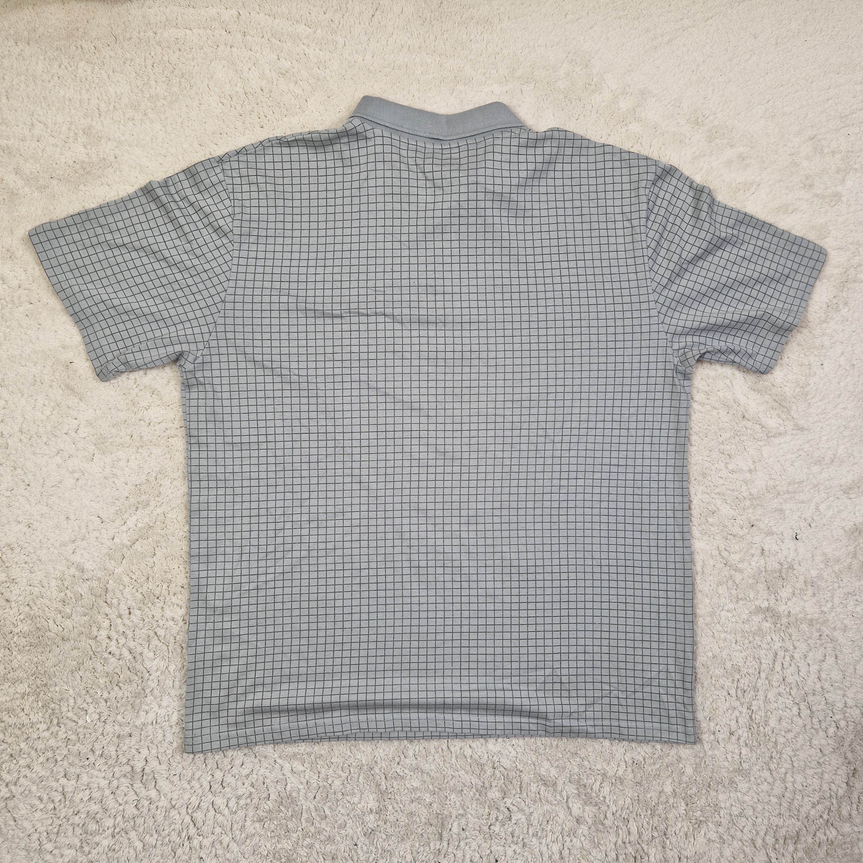 Gray checkered sleeveless top on a beige carpet