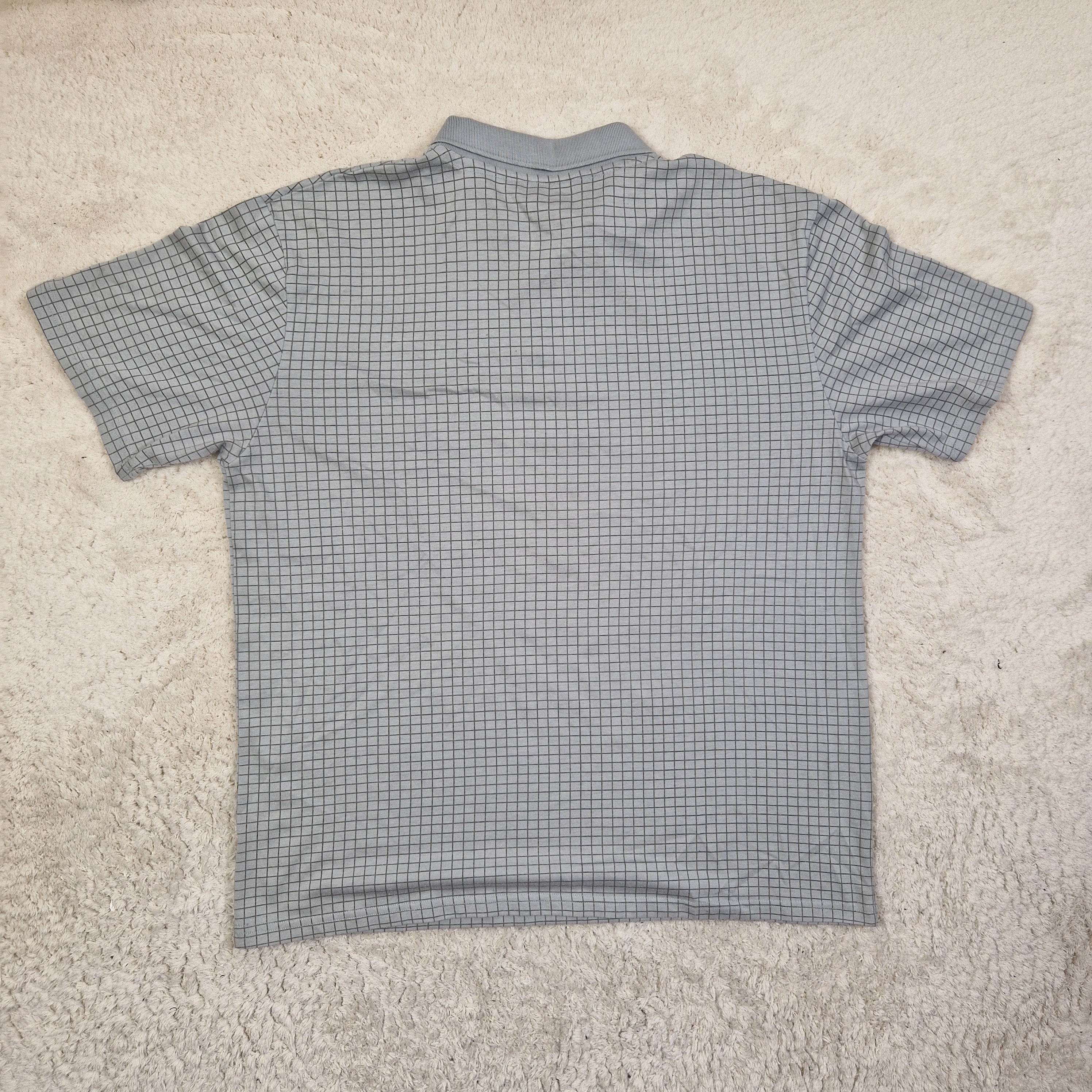 Gray checkered shirt on a beige carpet