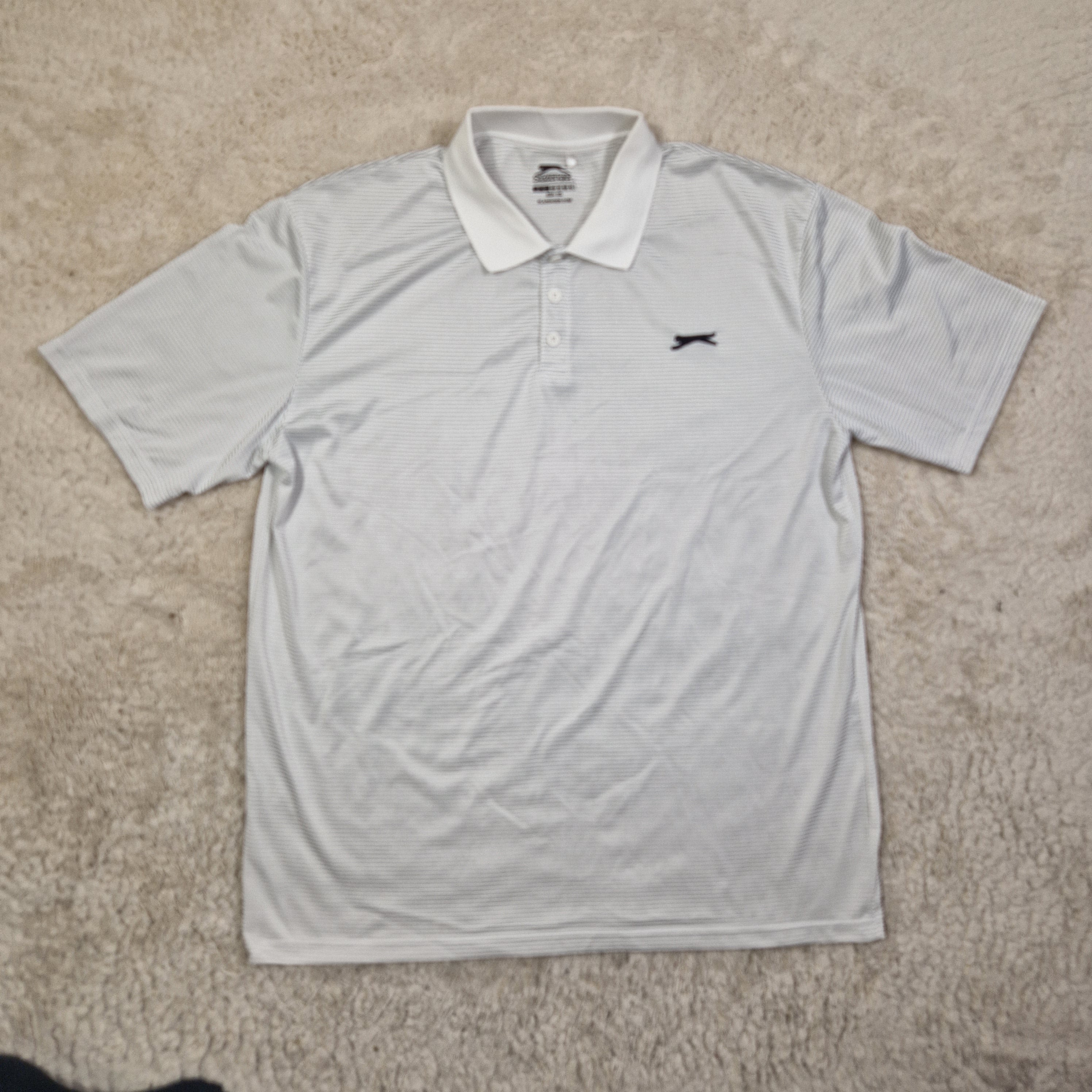 Gray long-sleeve shirt with a brand logo on a beige carpet