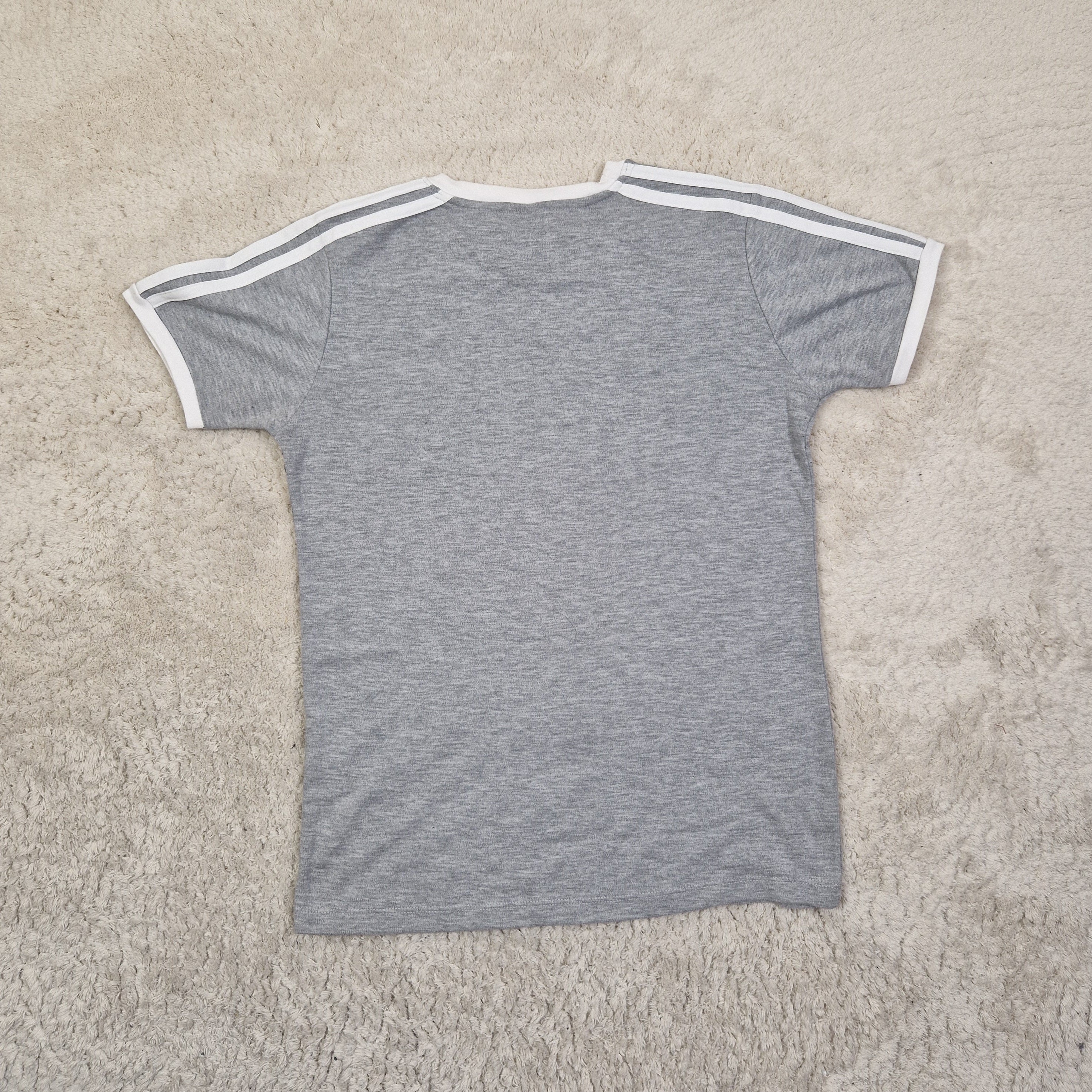 Gray t-shirt with white trim on a beige carpet