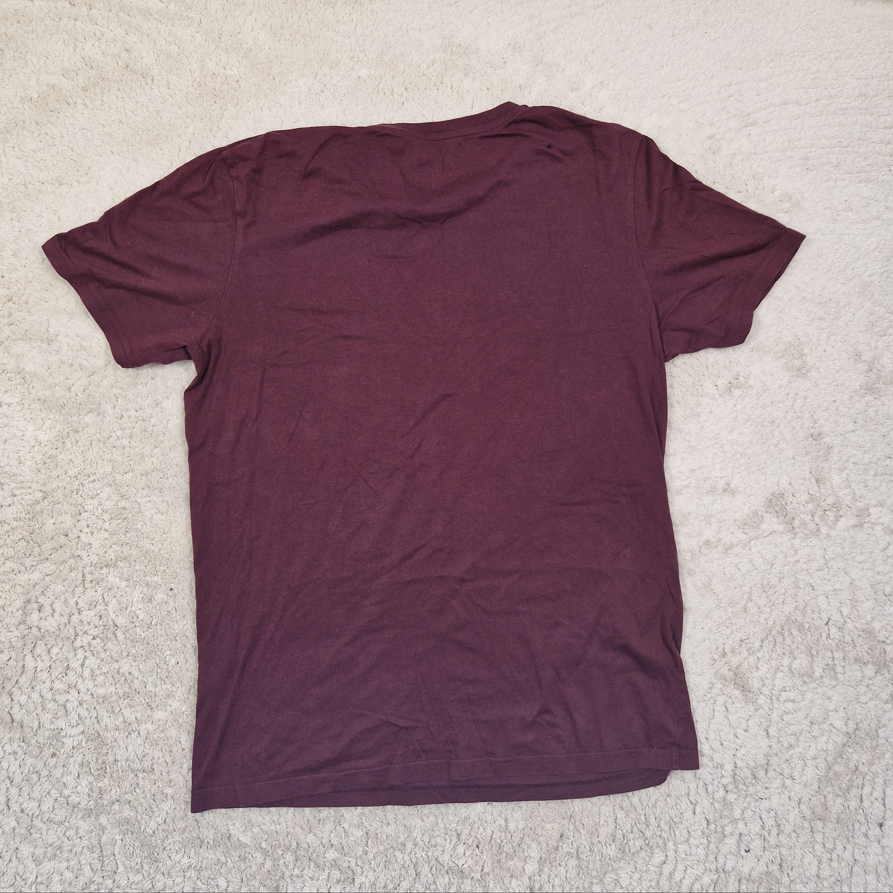 Purple t-shirt on a beige carpet