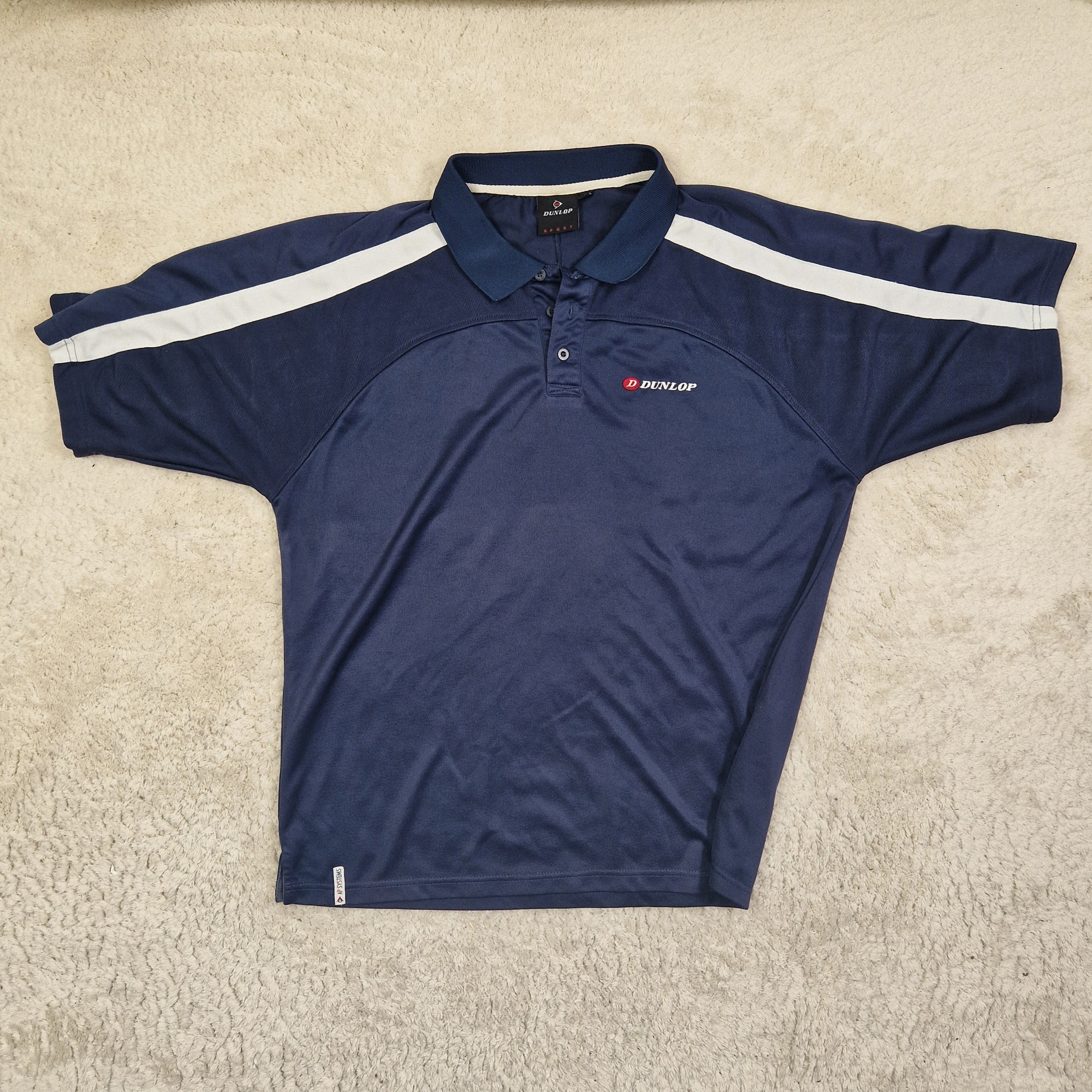 Navy blue athletic shirt with a white stripe on a beige carpet