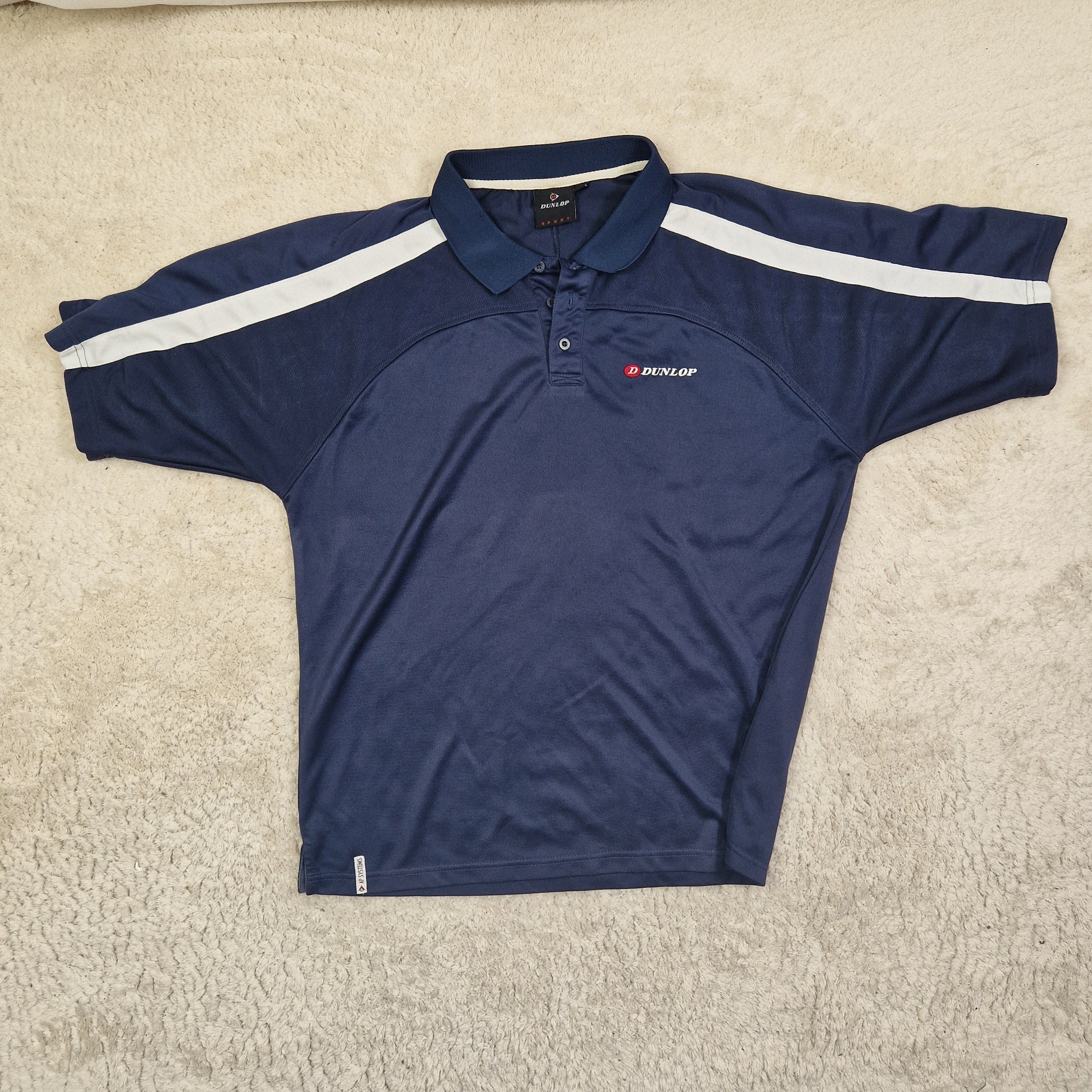 Navy blue athletic shirt with white stripe on a beige carpet