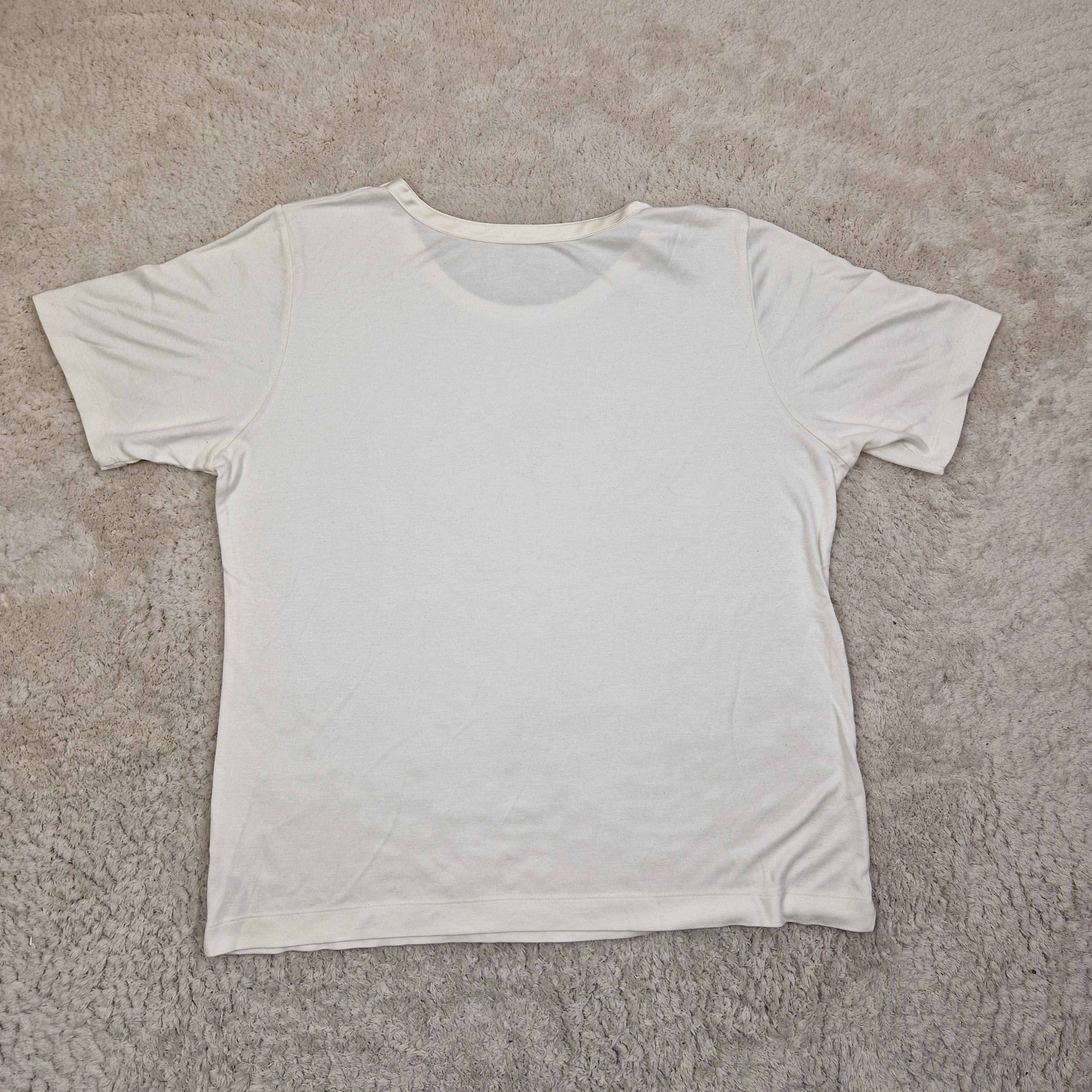 White sleeveless top on a beige carpet