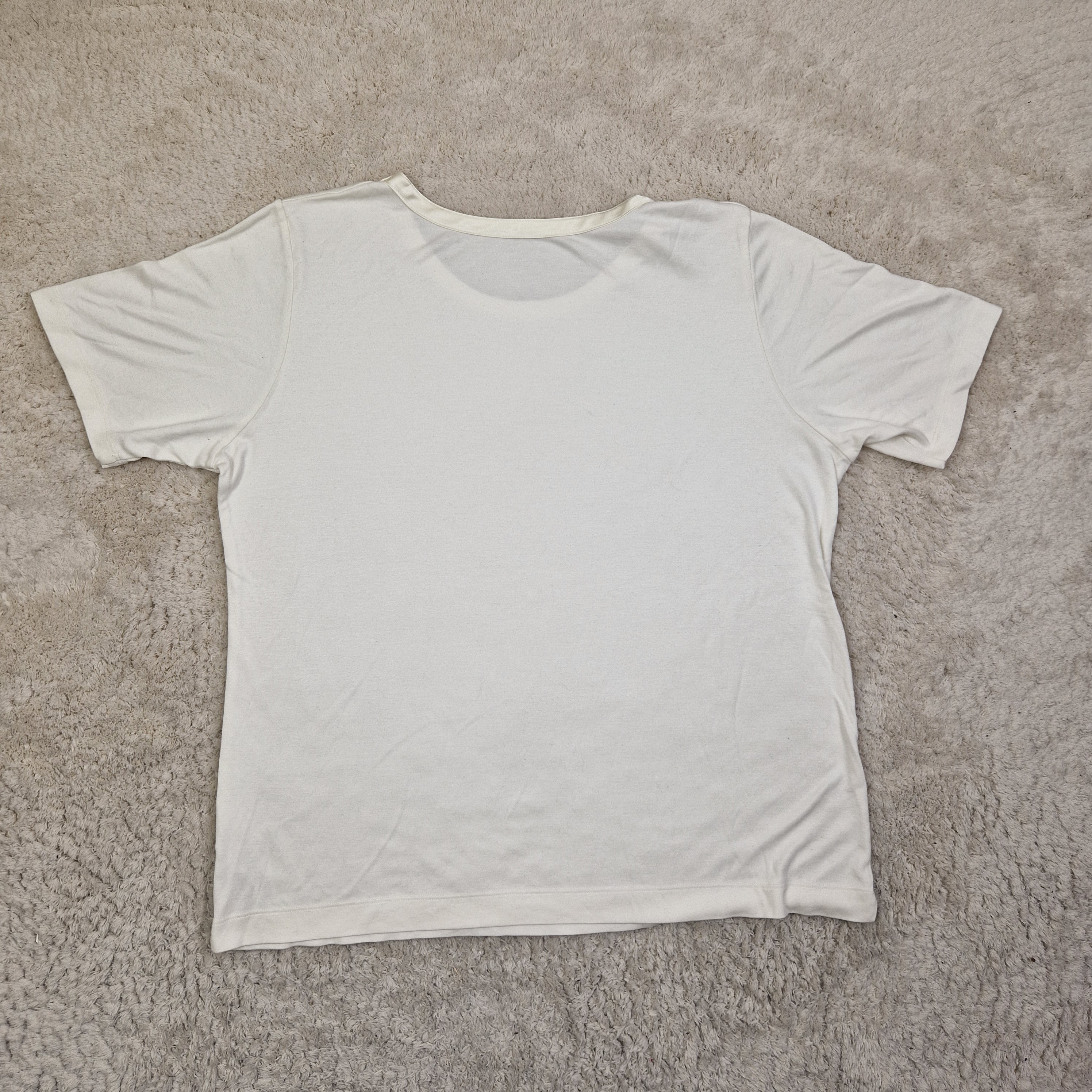 White sleeveless top on a beige carpet