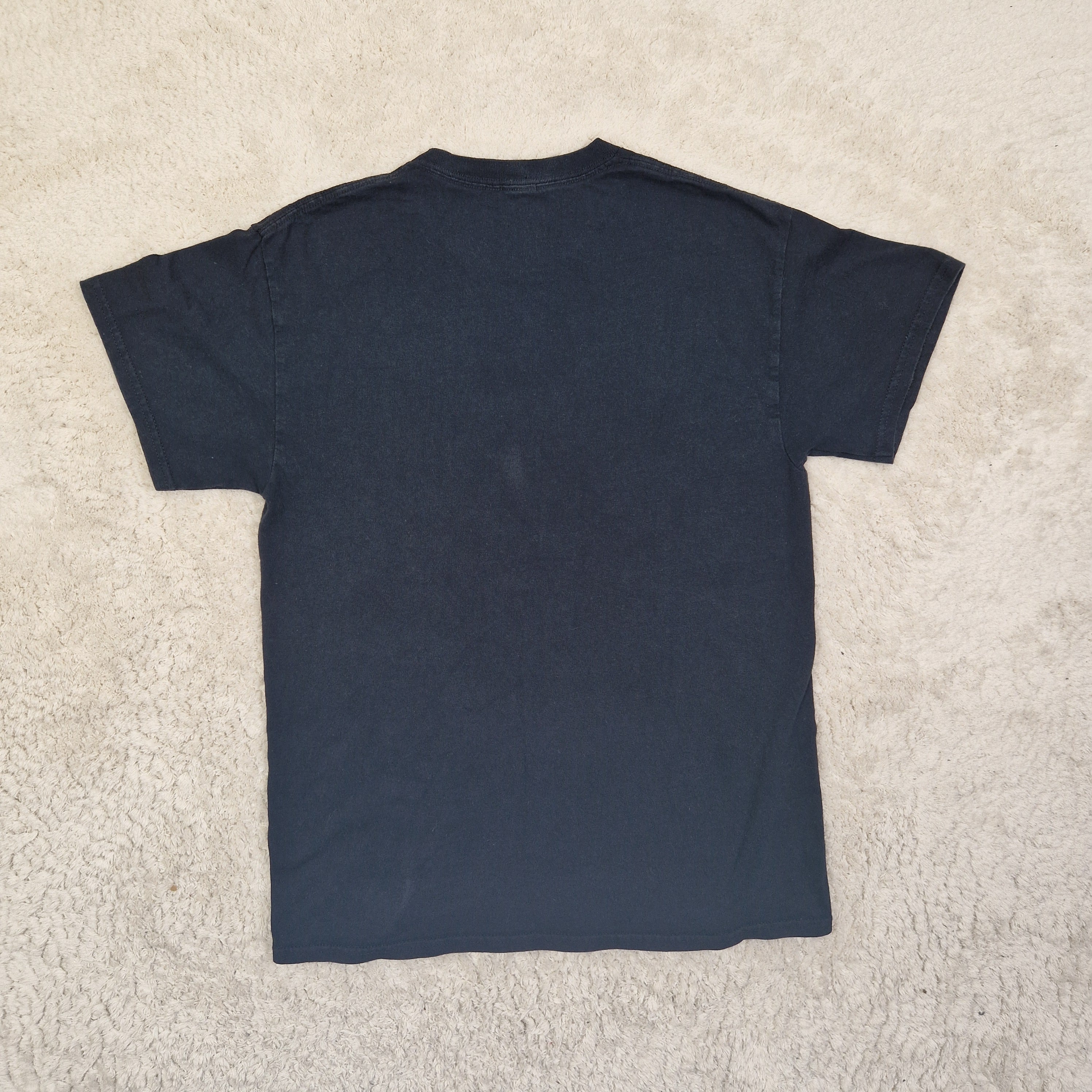 Folded navy blue shirt on a beige carpet