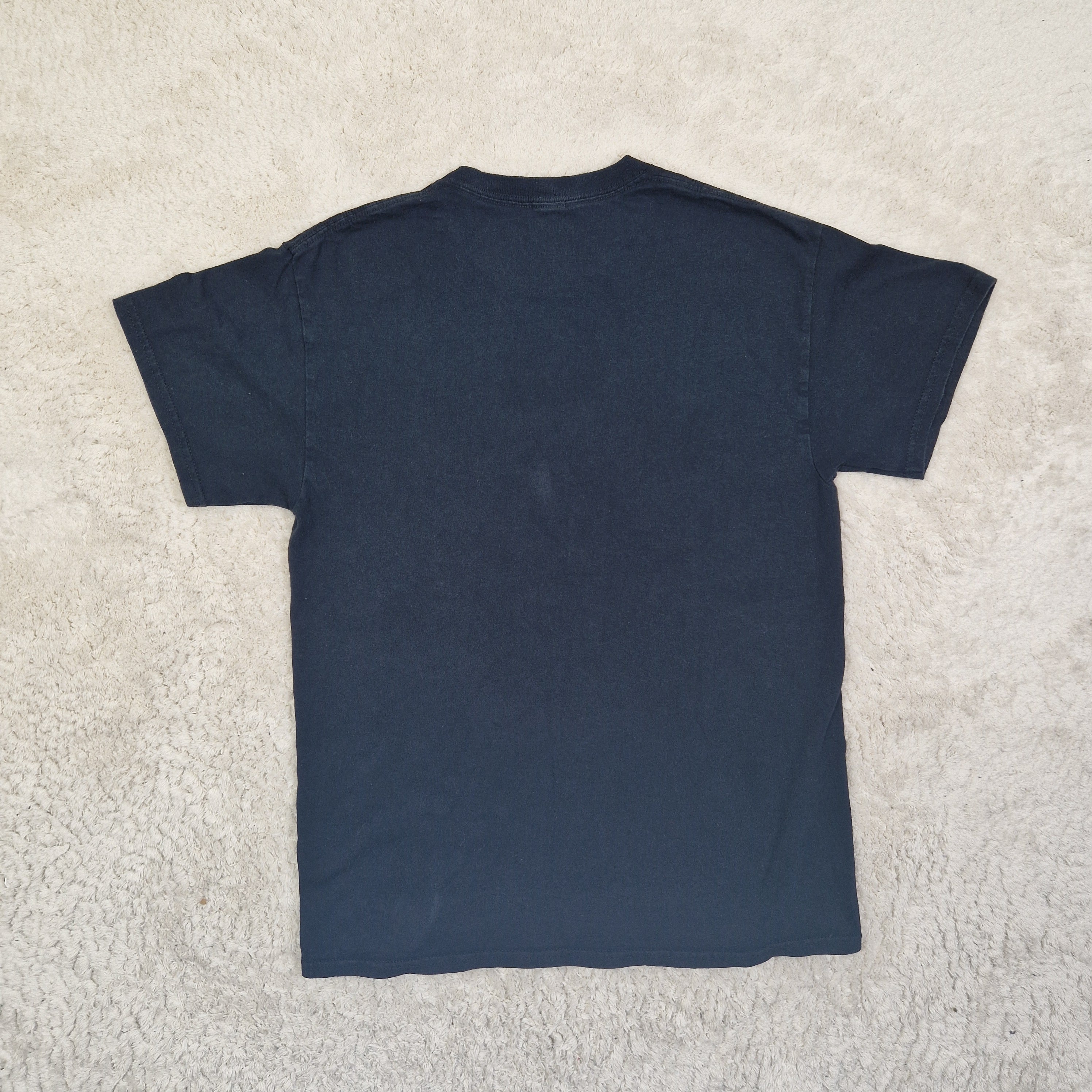 Folded navy blue shirt on a beige carpet