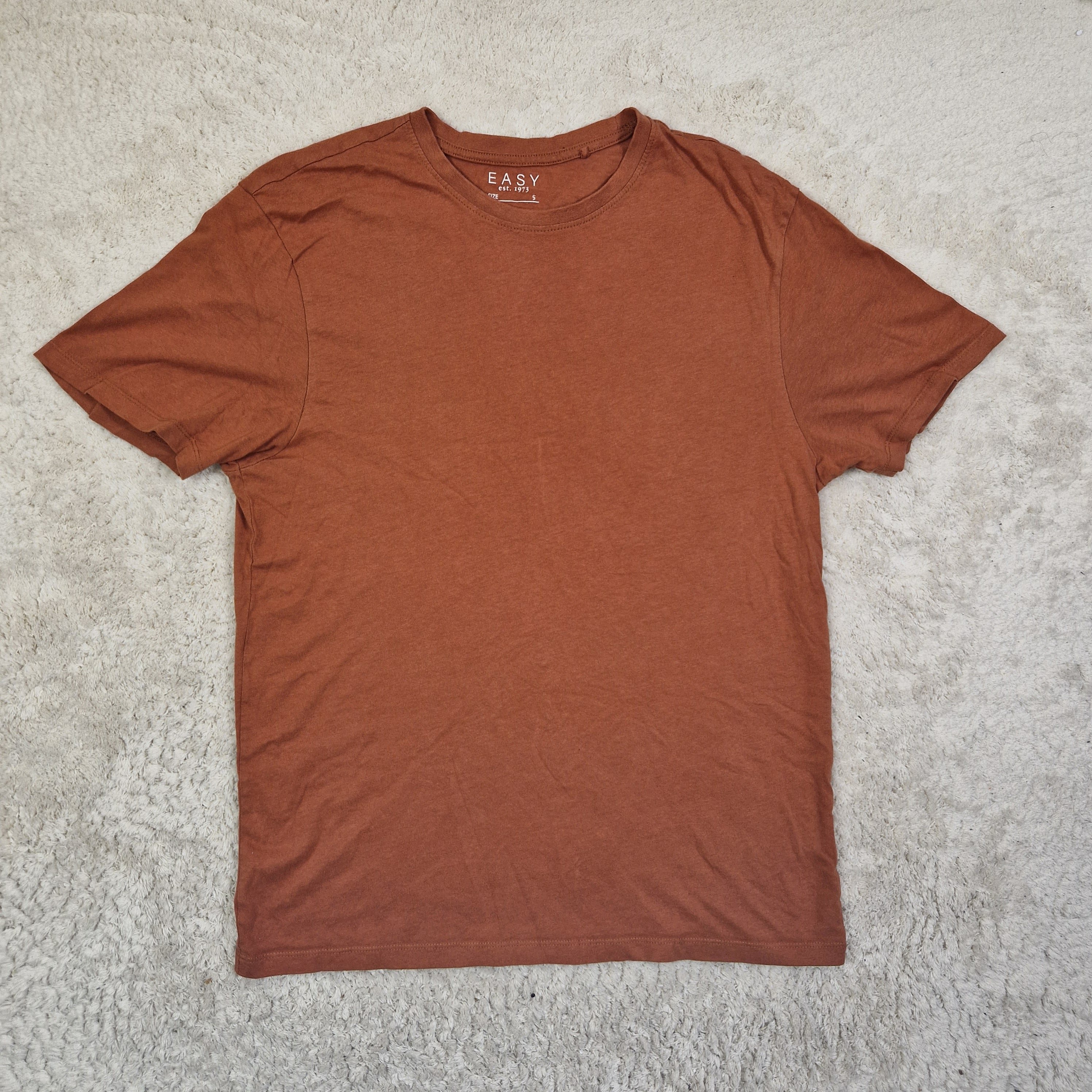 Brown t-shirt on a textured gray surface