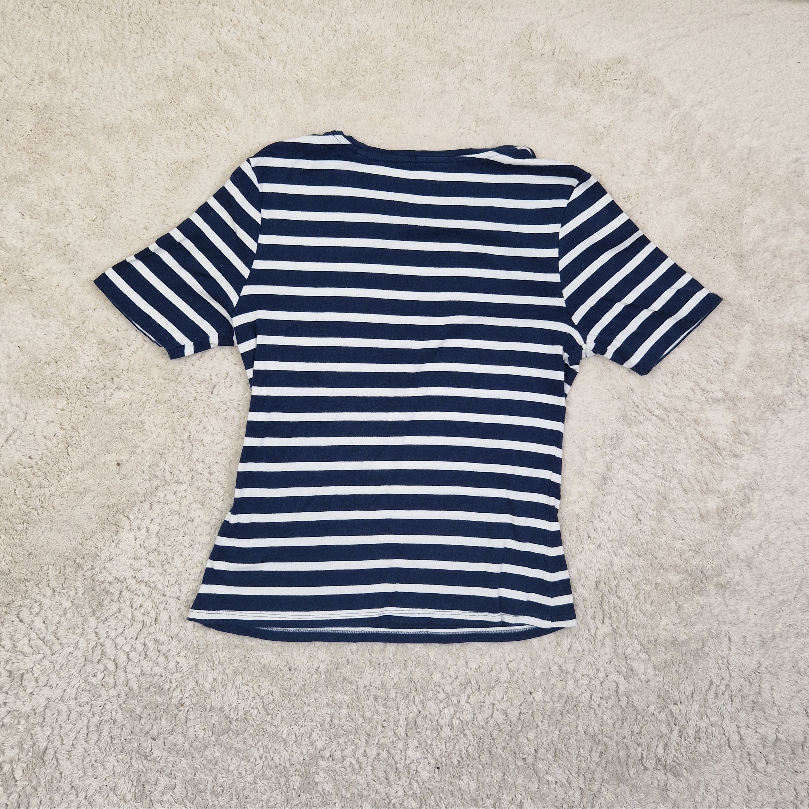 Navy and white striped shirt on a beige carpet