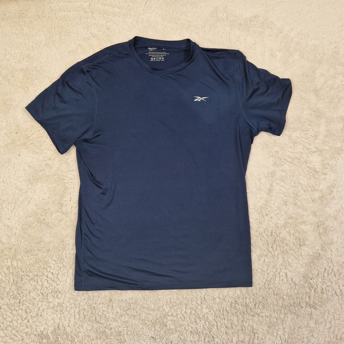 Folded navy blue t-shirt on a beige carpet