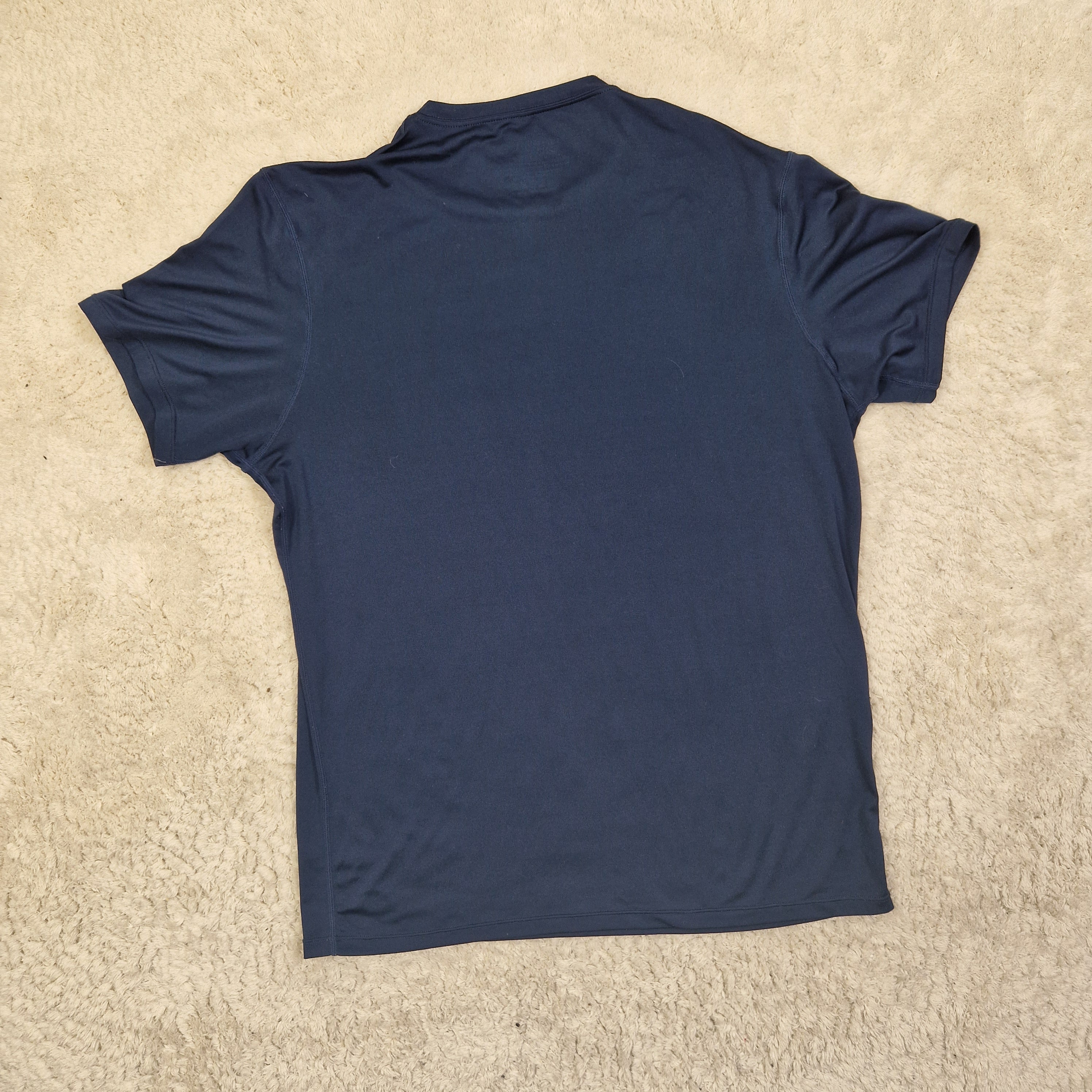 Navy blue t-shirt on a beige carpet