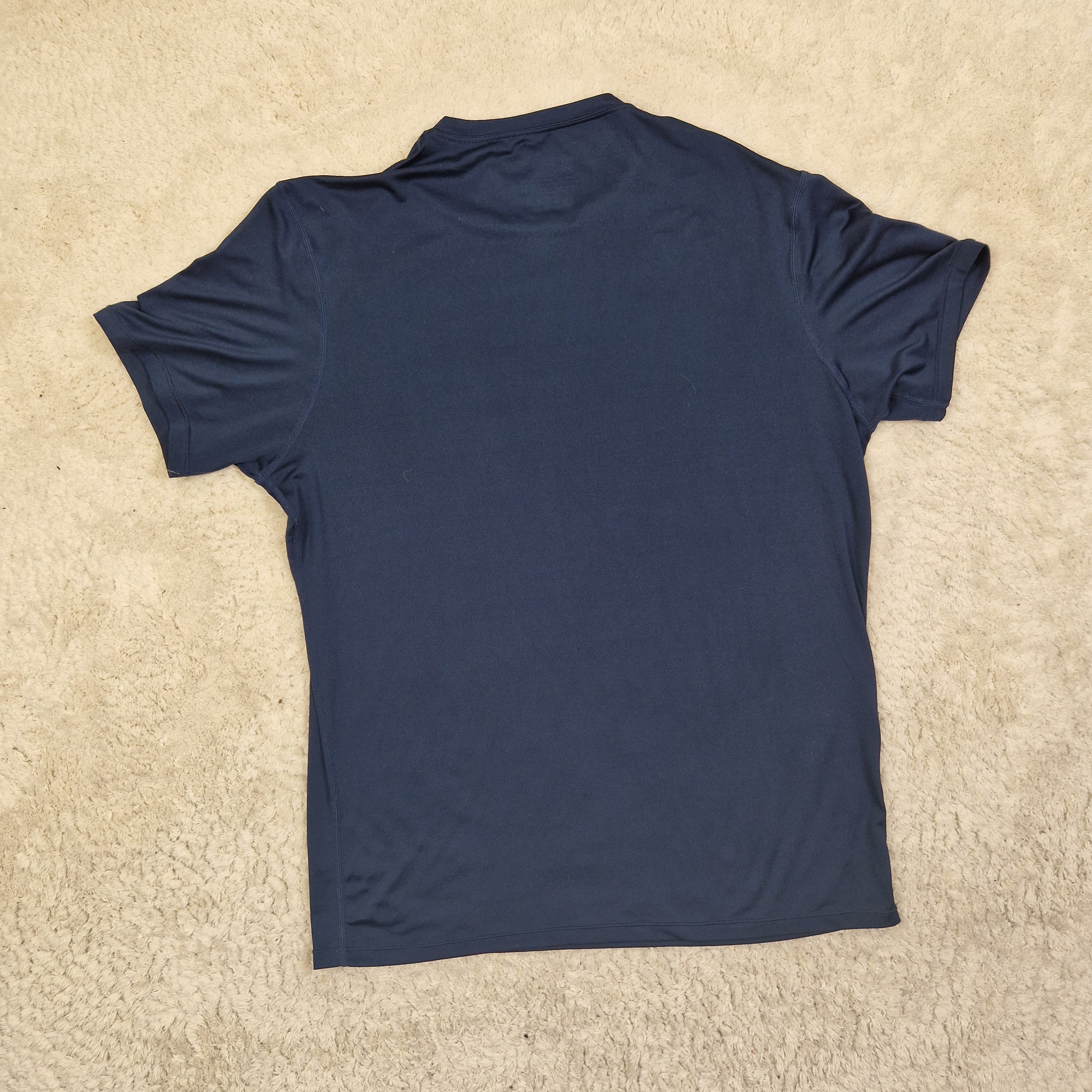 Navy blue t-shirt on a beige carpet