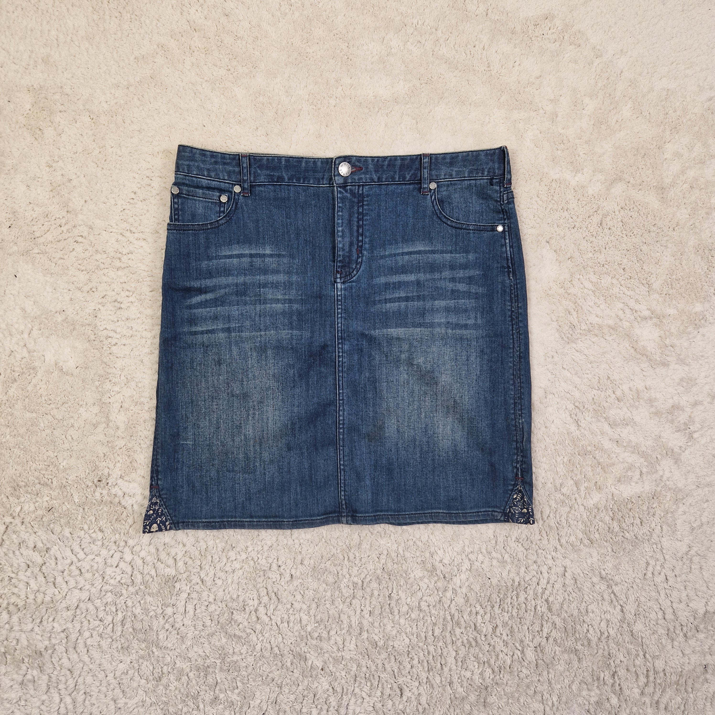 Blue denim skirt on a beige carpet