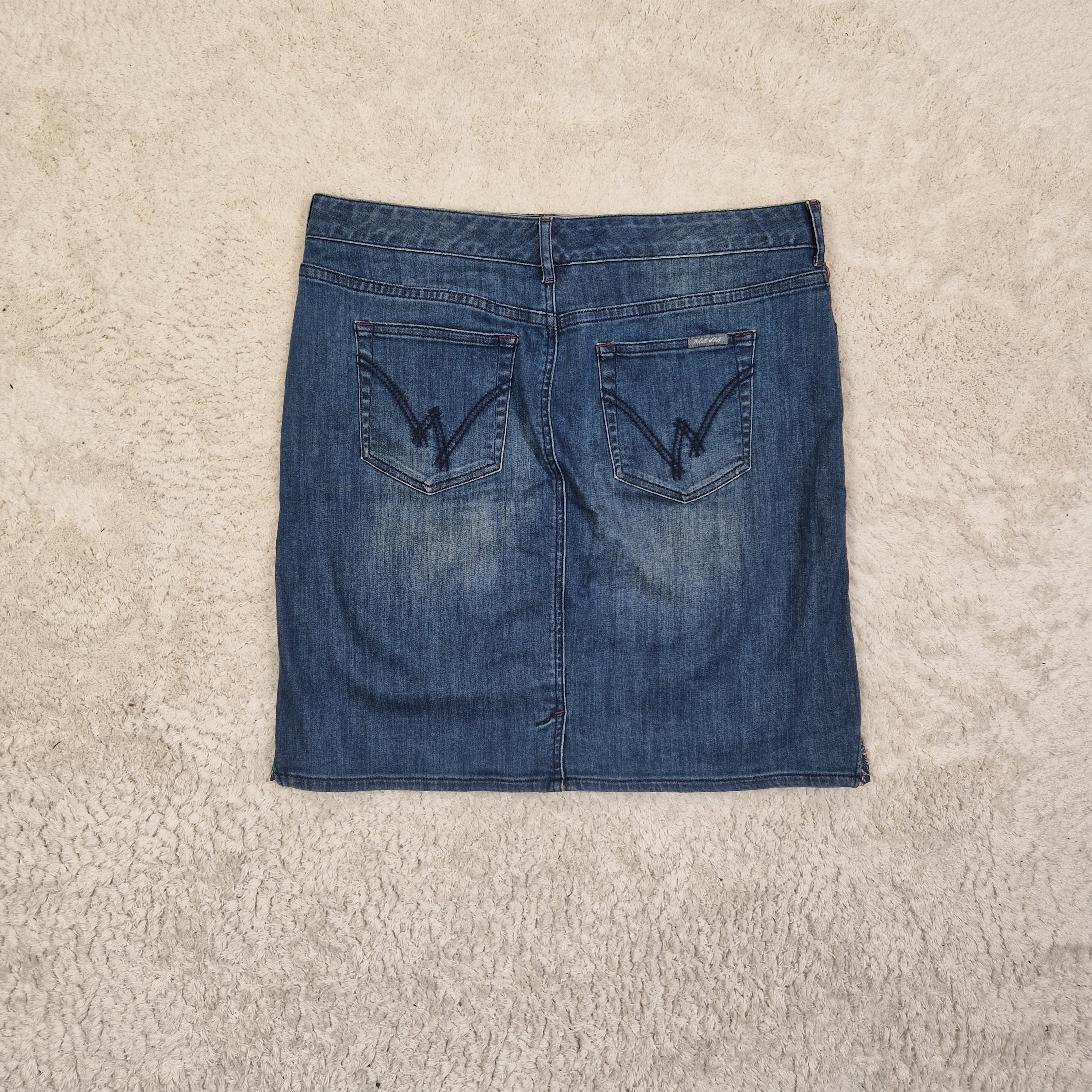 Folded blue jeans on a beige carpet