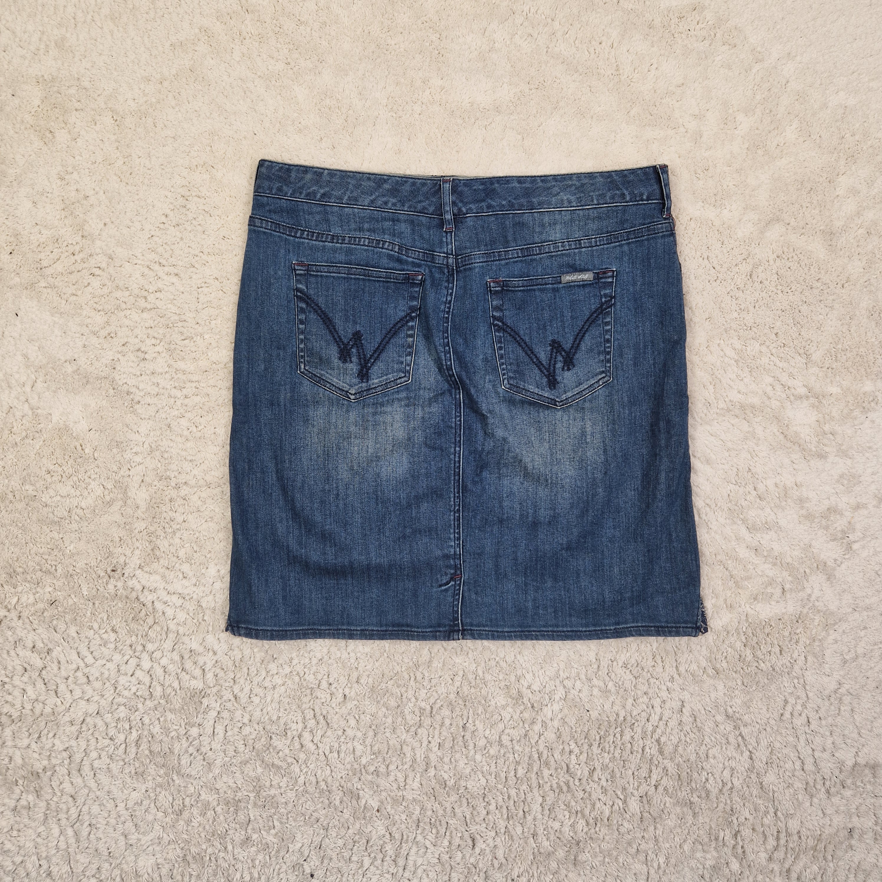 Folded blue denim jeans on a beige carpet