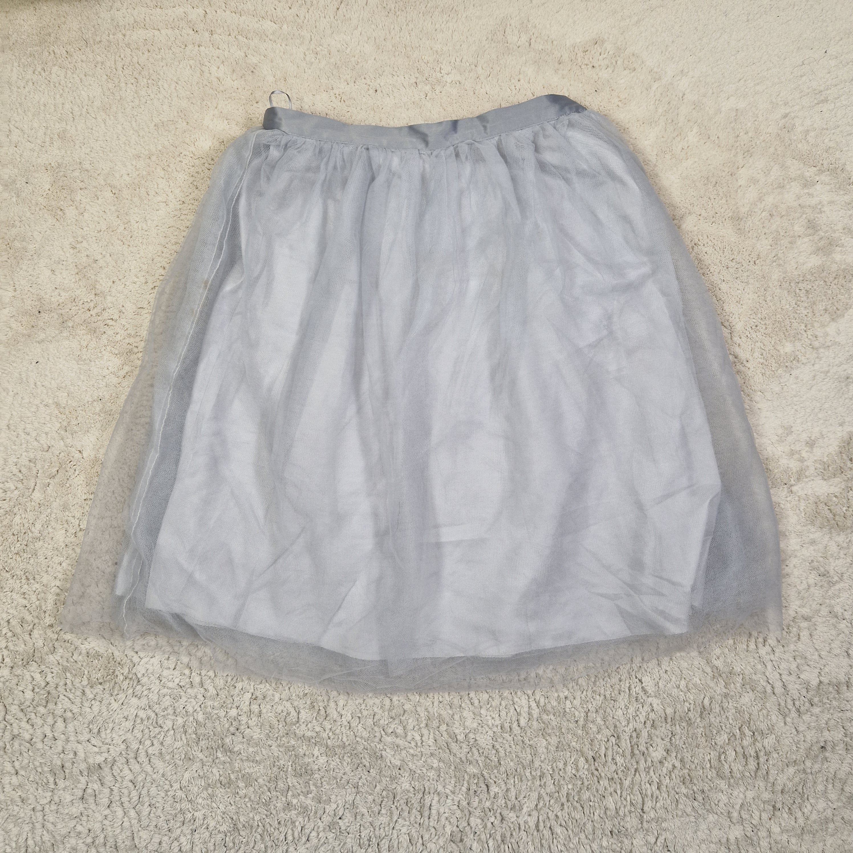Gray garment in a clear plastic bag on a beige carpet