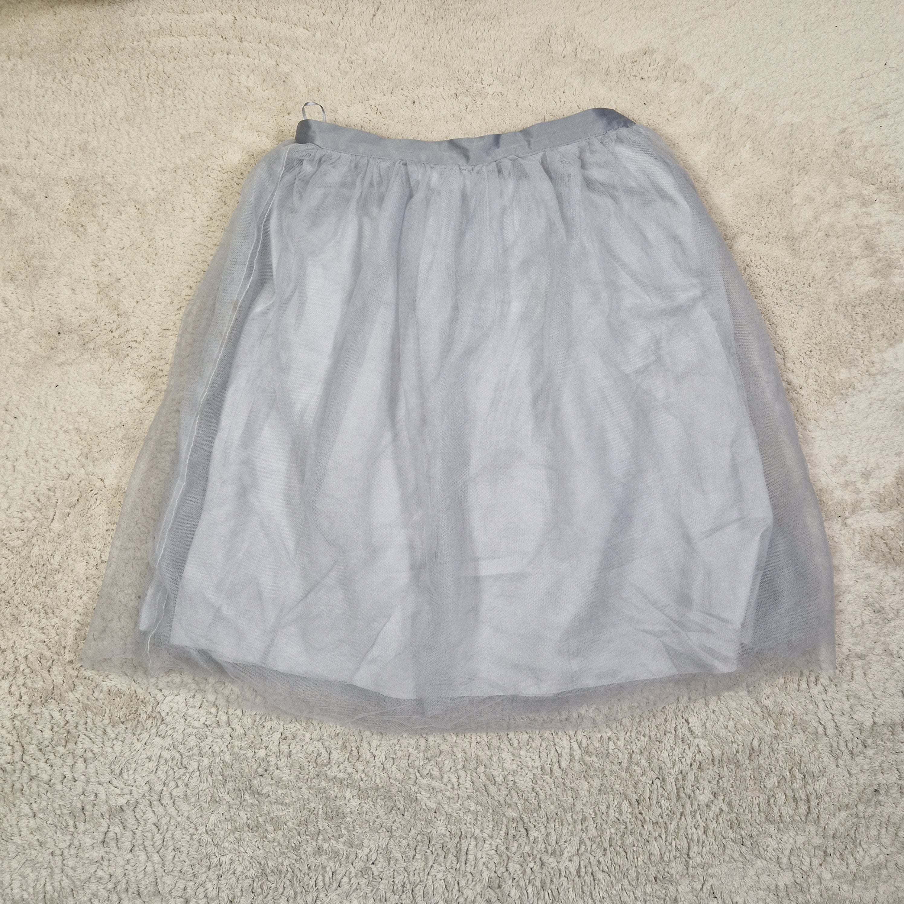 Light blue strapless top on a beige carpet