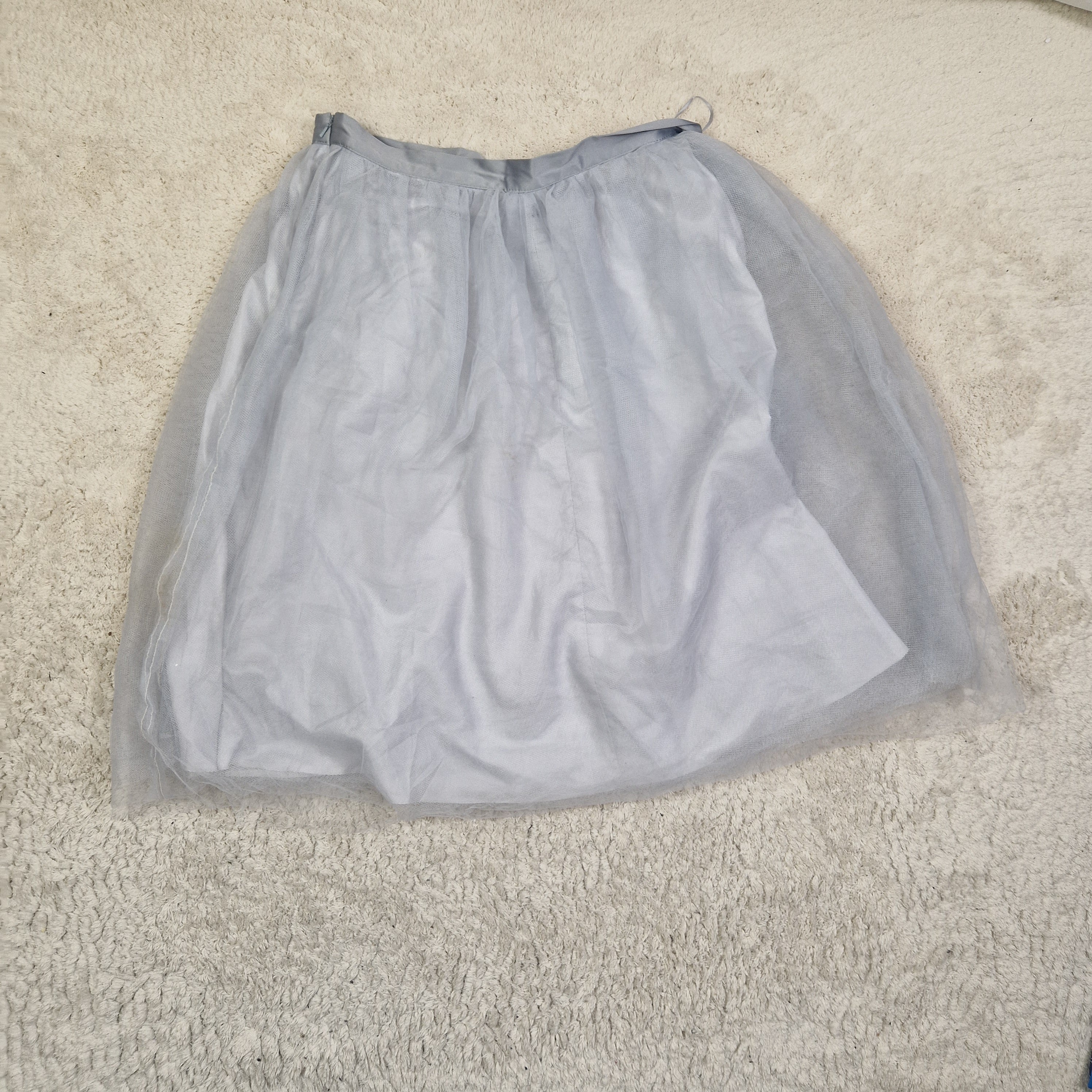 Gray mesh bag on a beige carpet