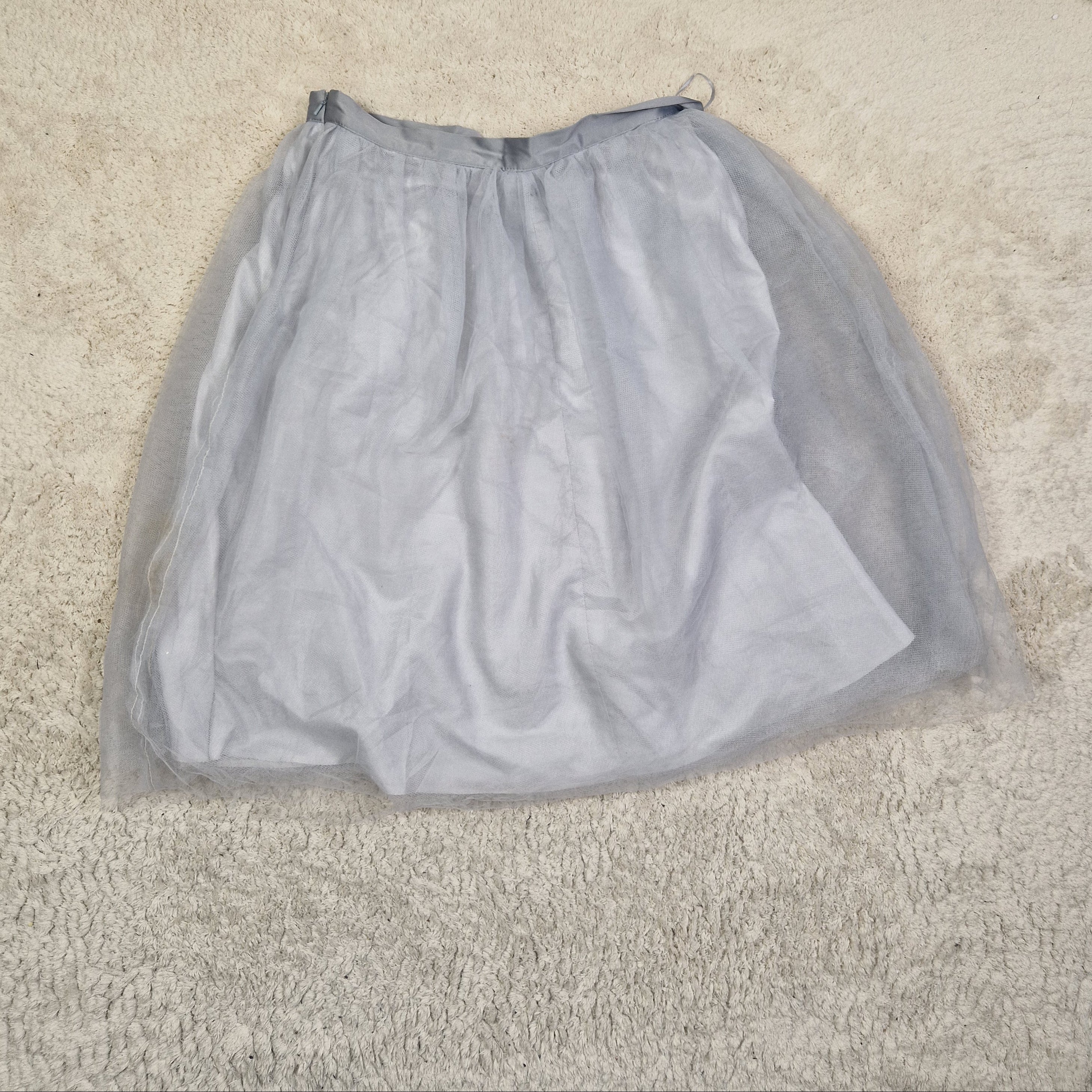 Gray mesh bag on a beige carpet