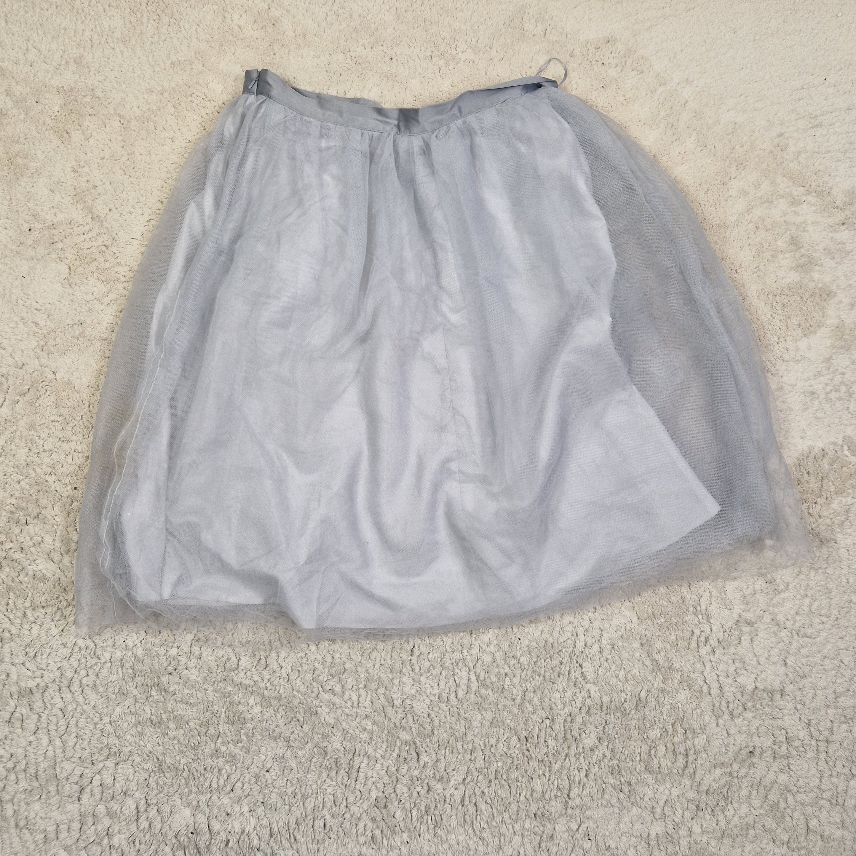 Gray mesh bag on a beige carpet