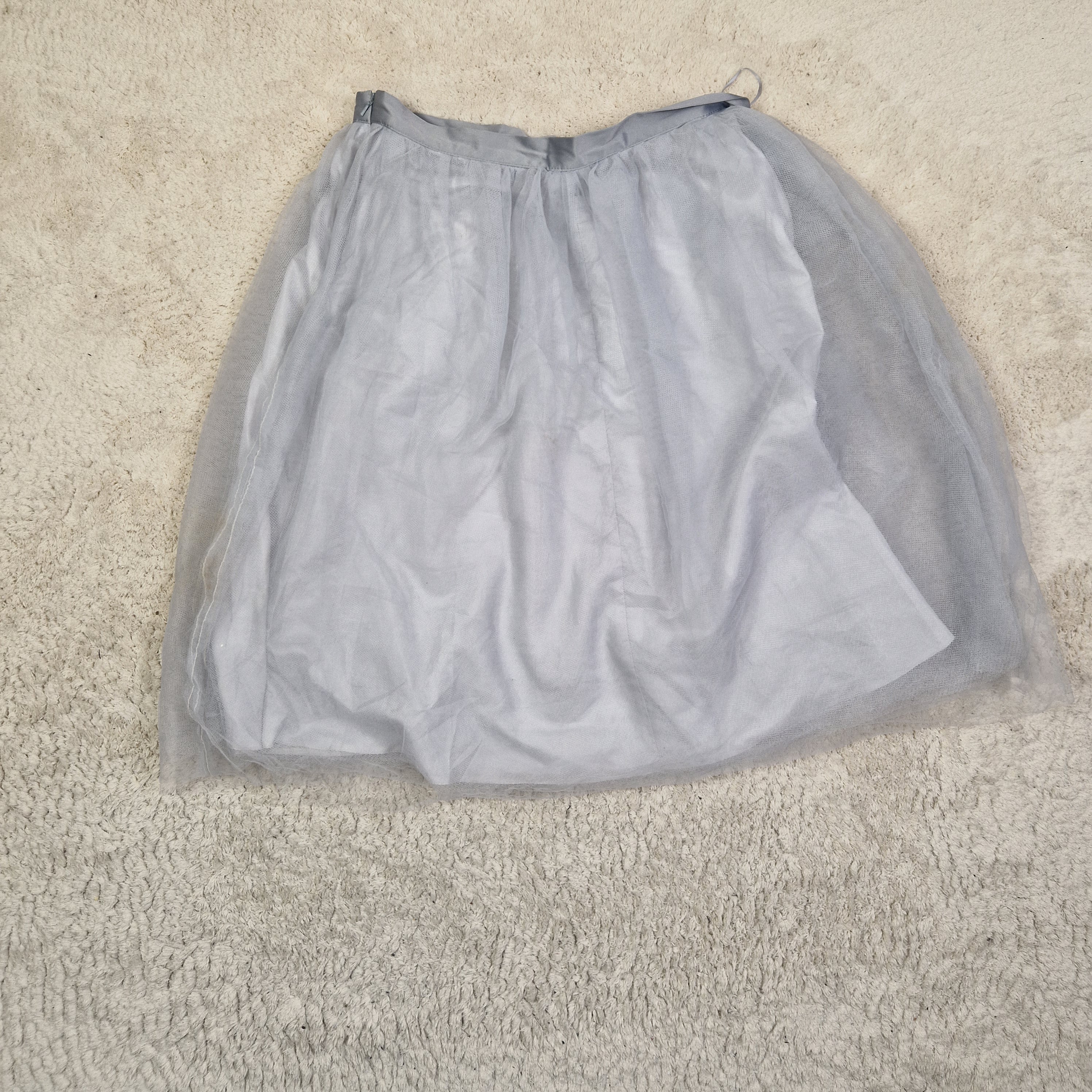Gray strapless top on a beige carpet