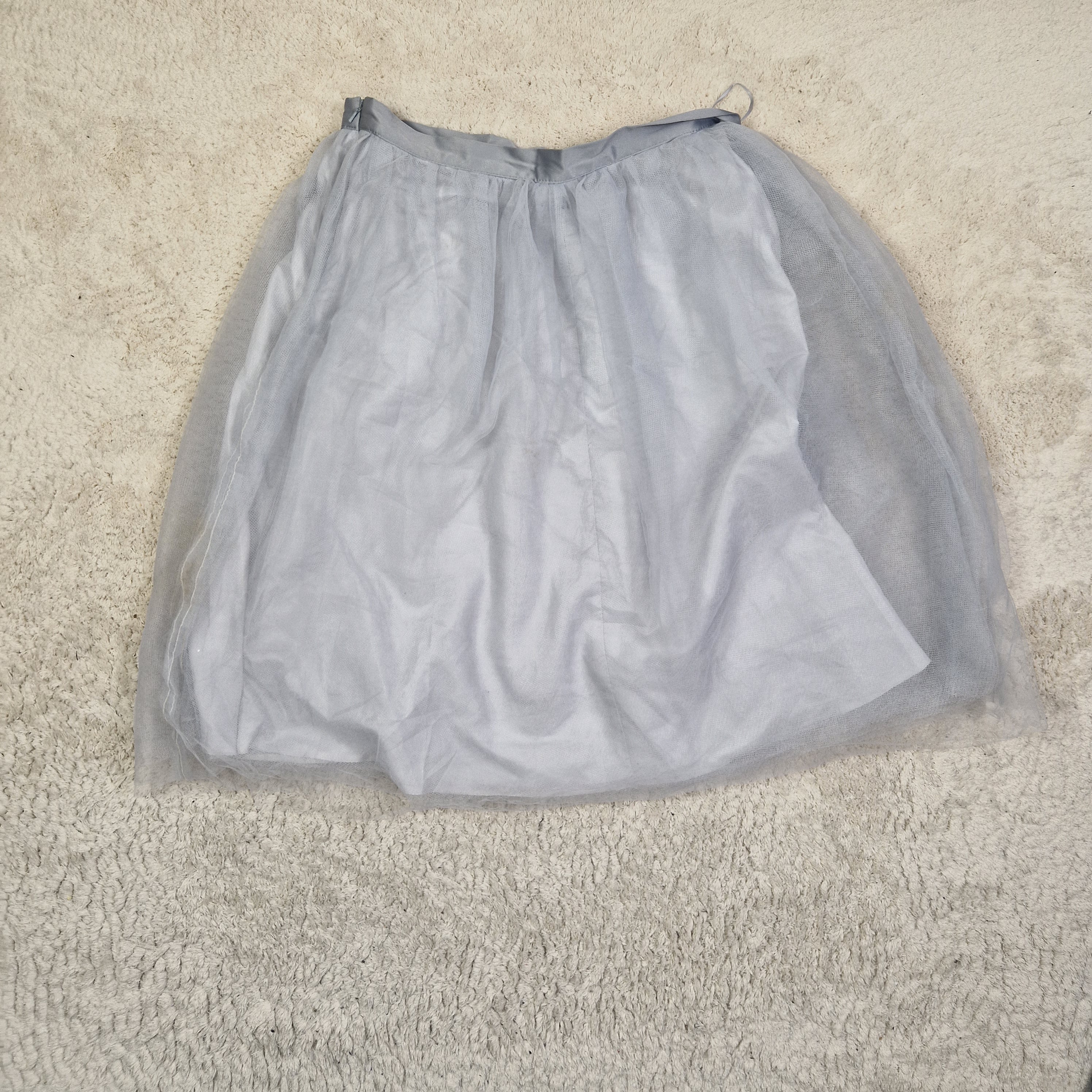 Gray drawstring bag on a beige carpet