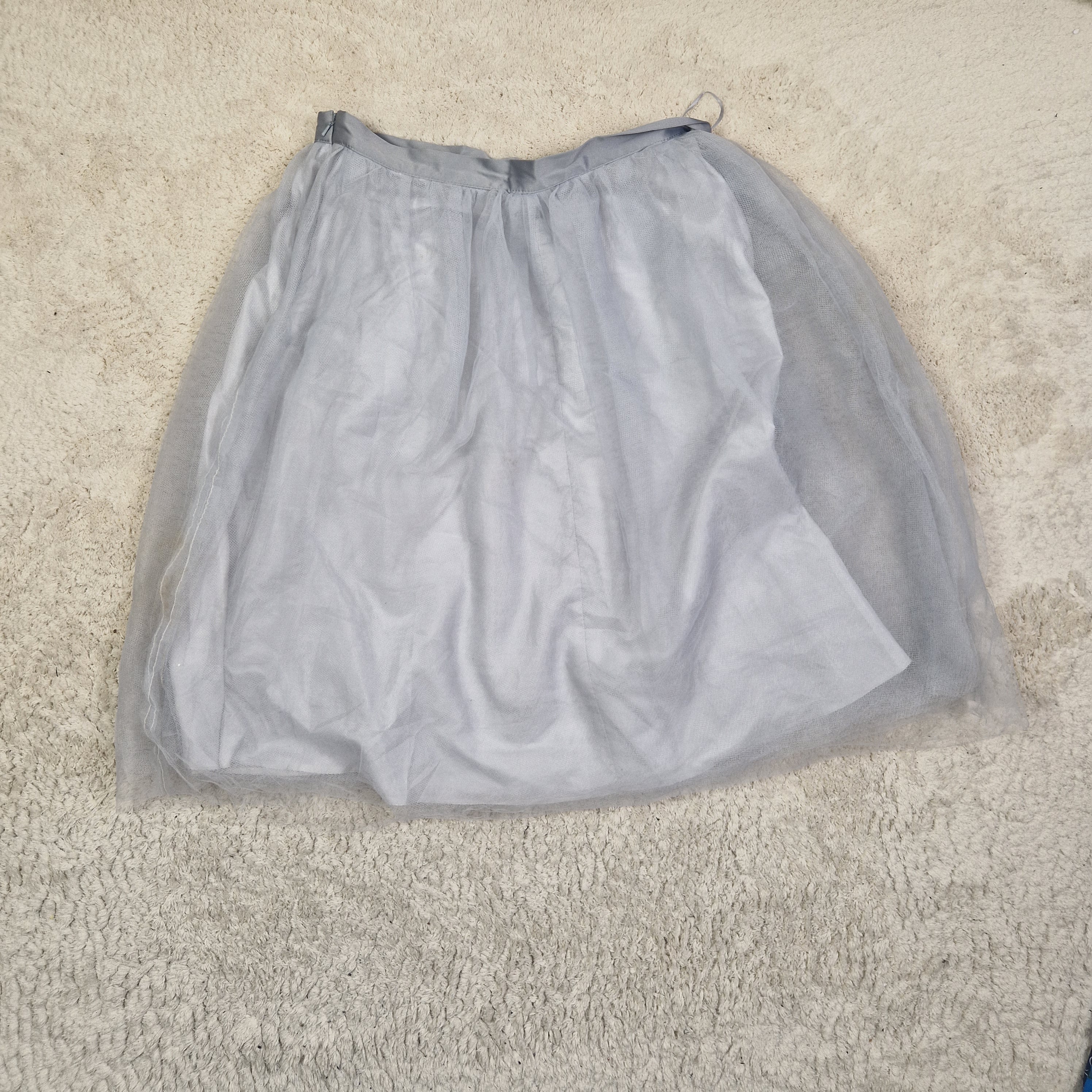 Gray mesh bag on a beige carpet