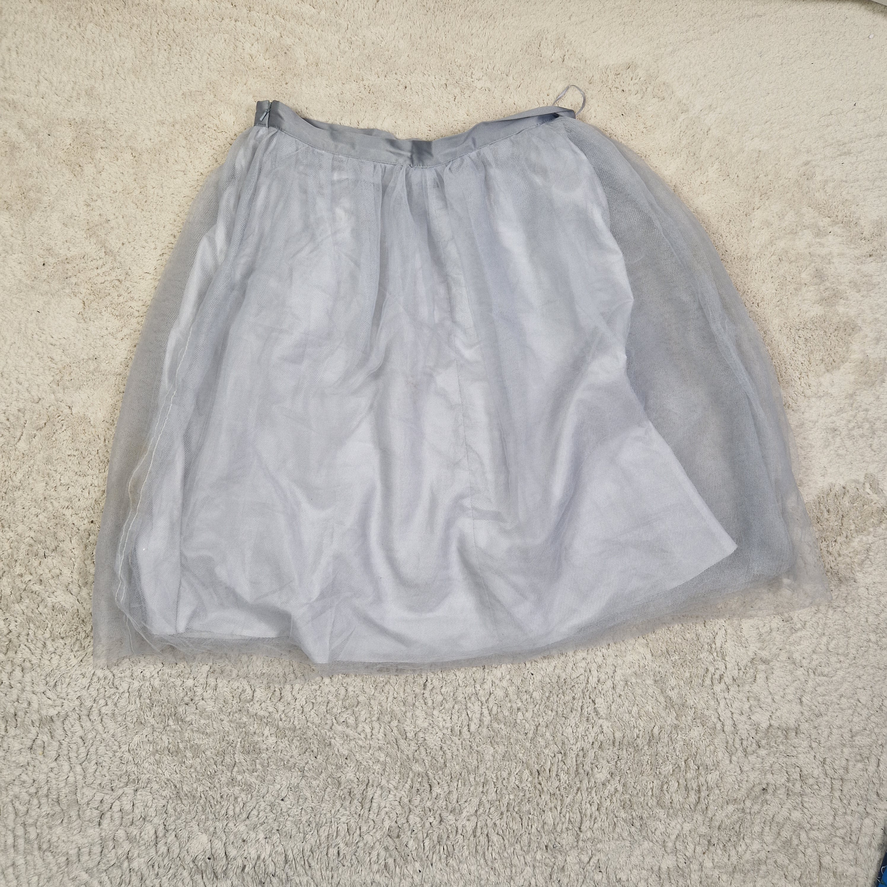Gray garment in a clear plastic bag on a beige carpet