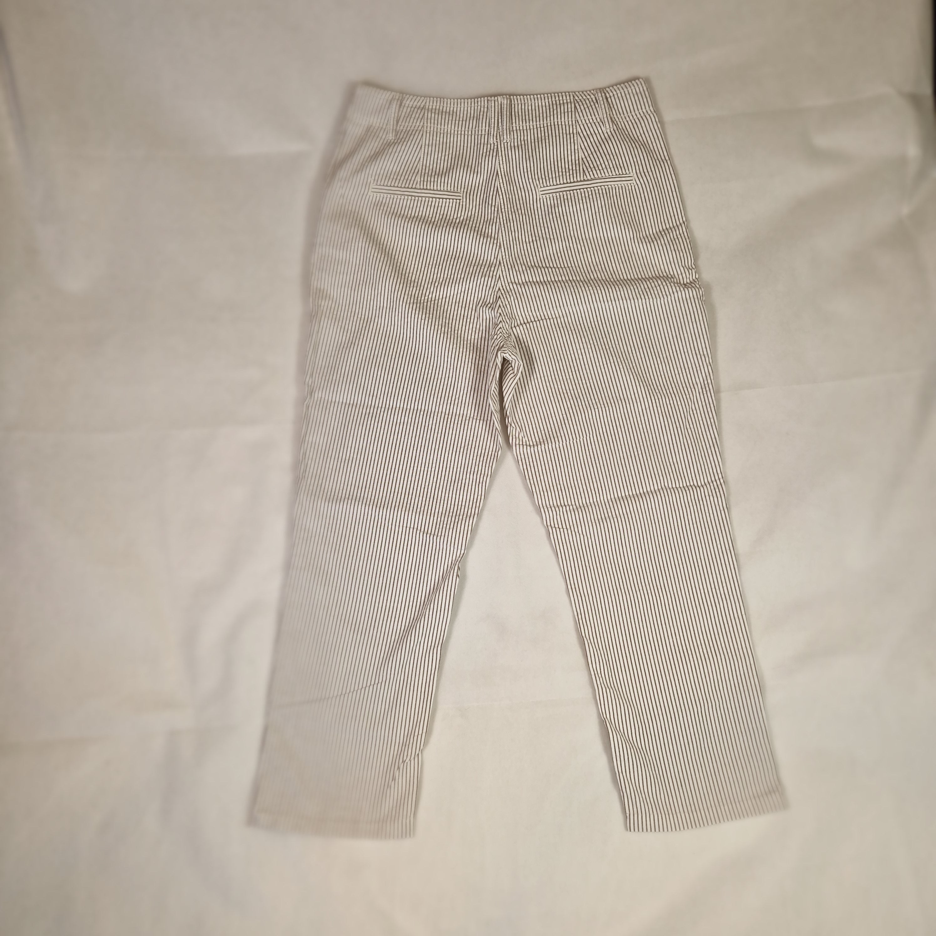 Folded gray pants on a light beige surface