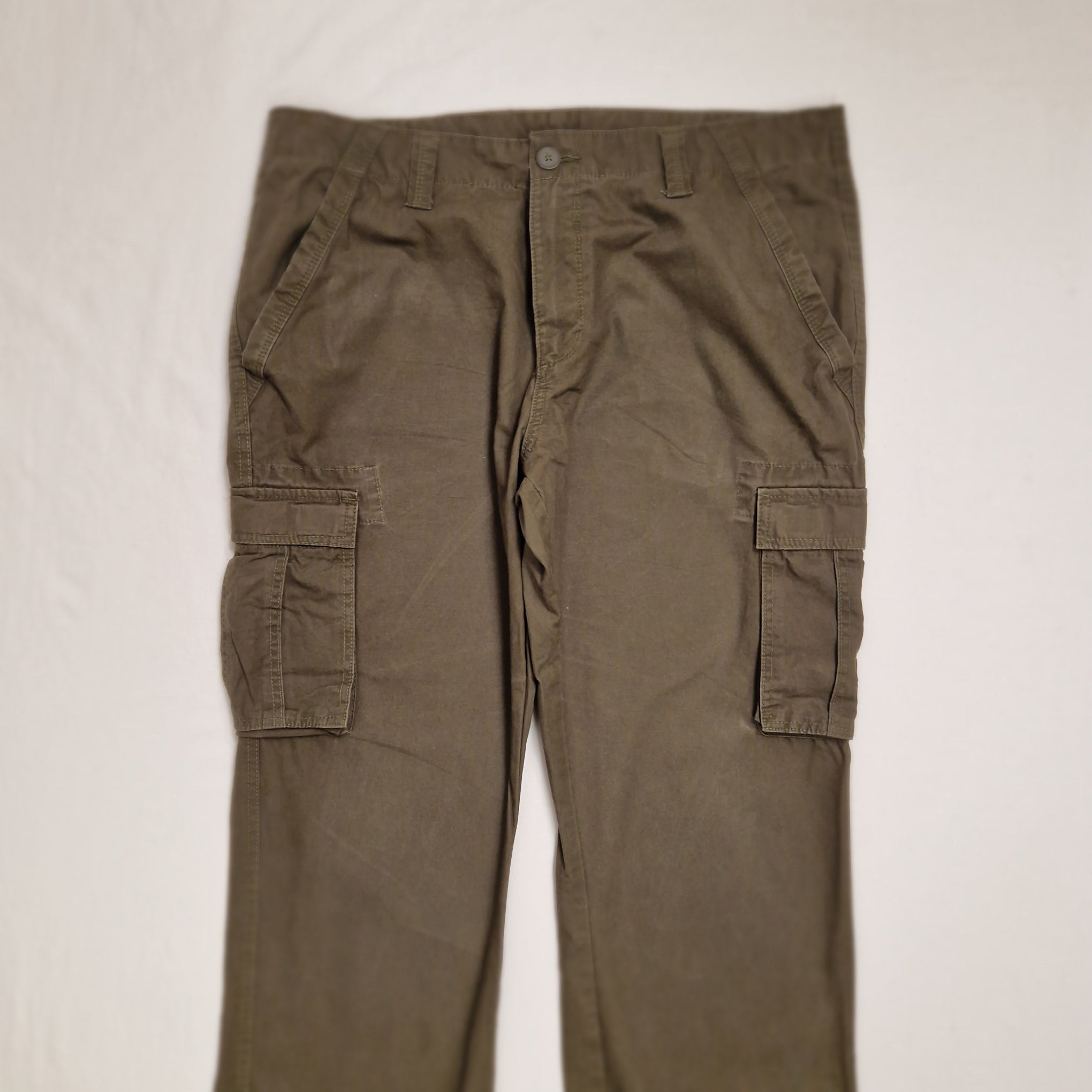 A pair of olive green cargo pants laid flat against a light off-white background.